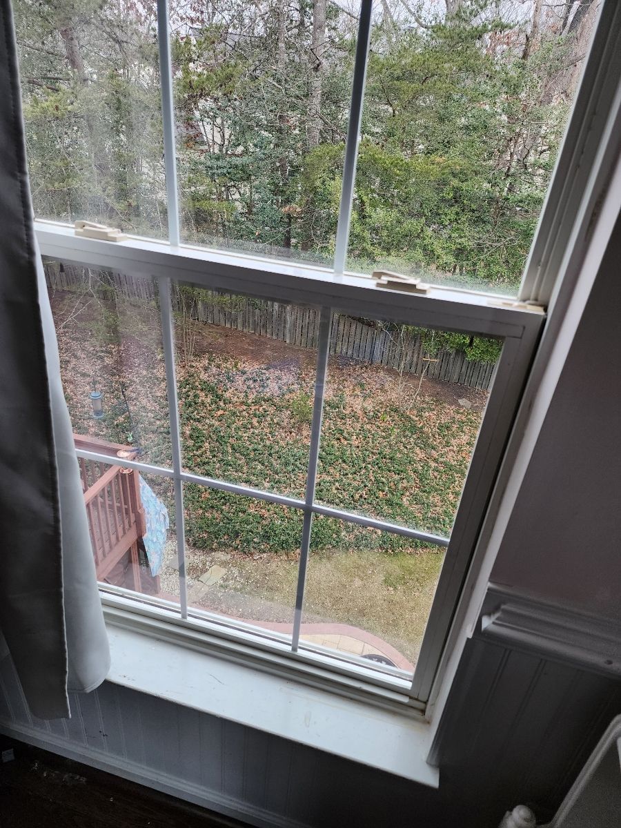 Stone outdoor pavilion with a dark wooden roof, built-in grill, and bench seating.
