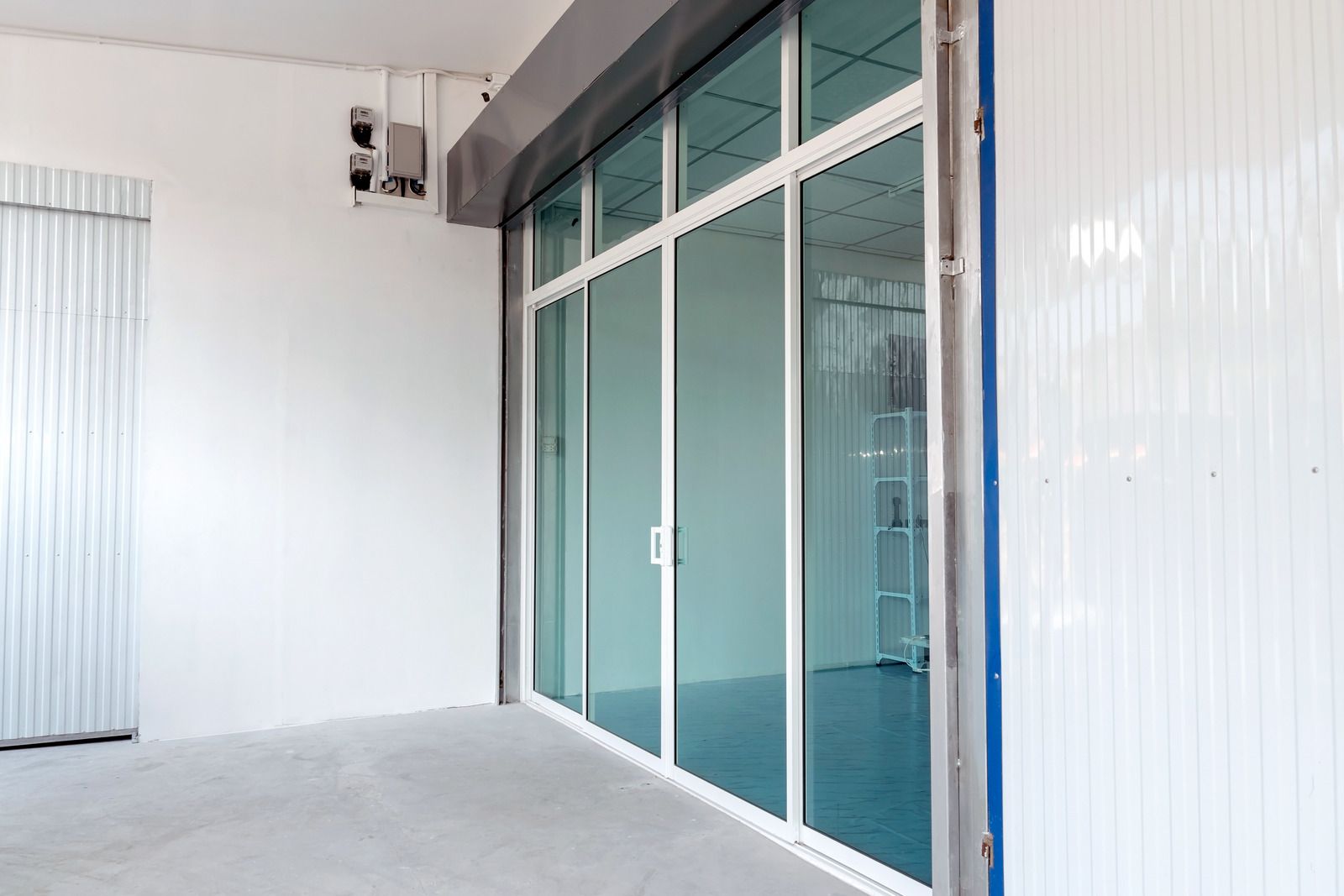 An empty building with a lot of windows and a sliding glass door.