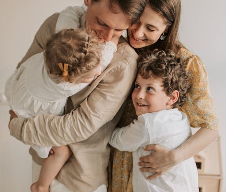 Experienced family dentist in Pennsauken Township, NJ. A family is hugging each other on a bed.