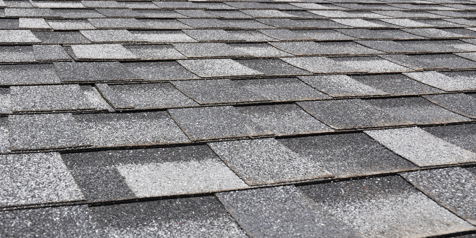 Close-up of gray asphalt roof shingles in a repeating pattern