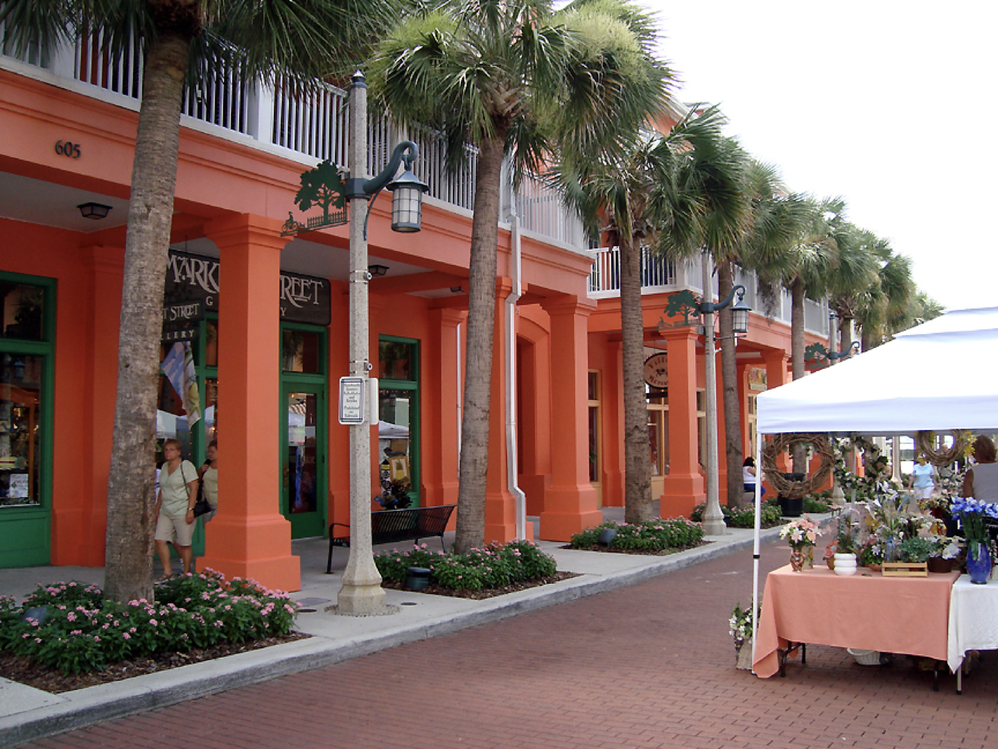 a row of orange buildings with palm trees in front of them
