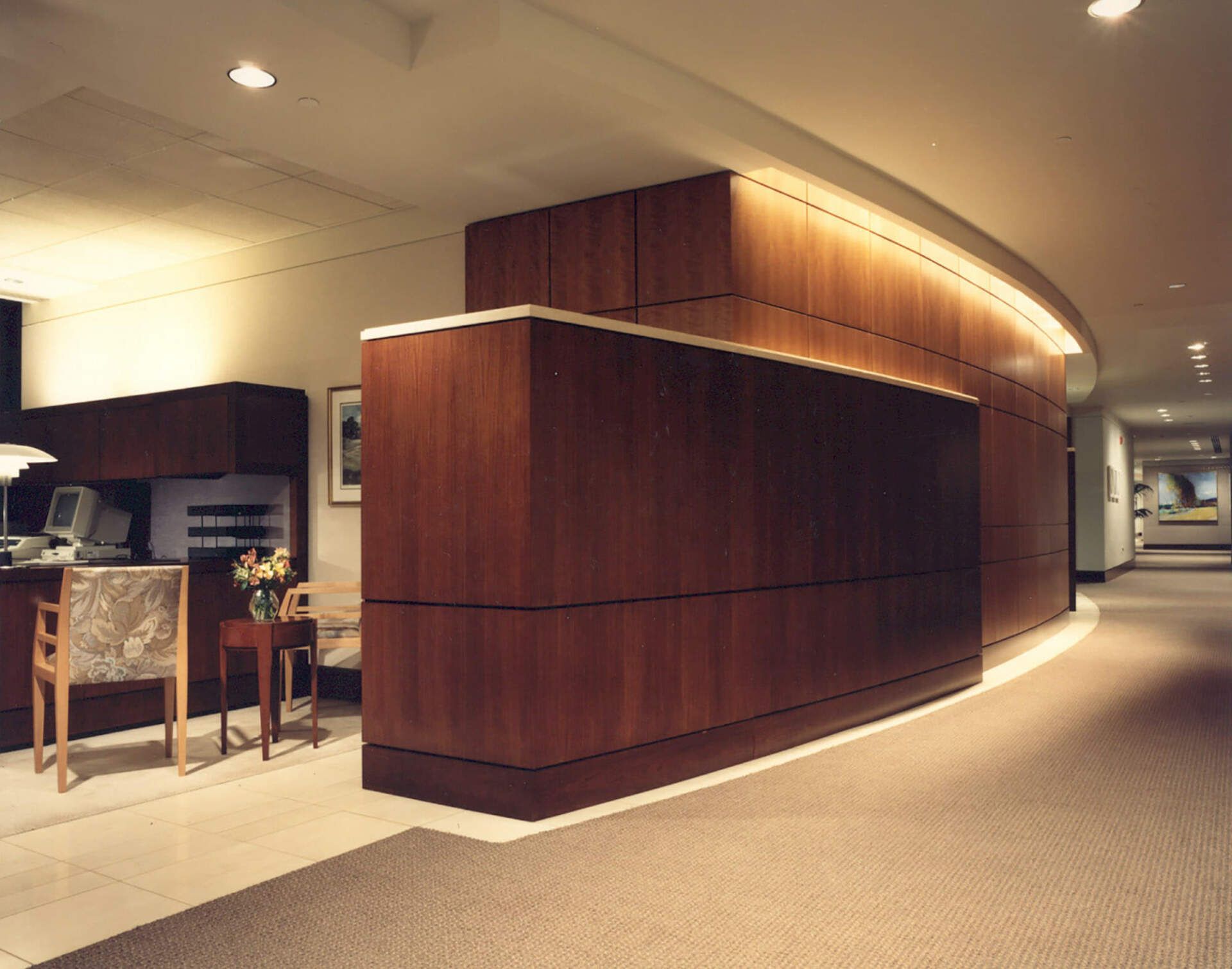 a long hallway with a wooden wall and a desk