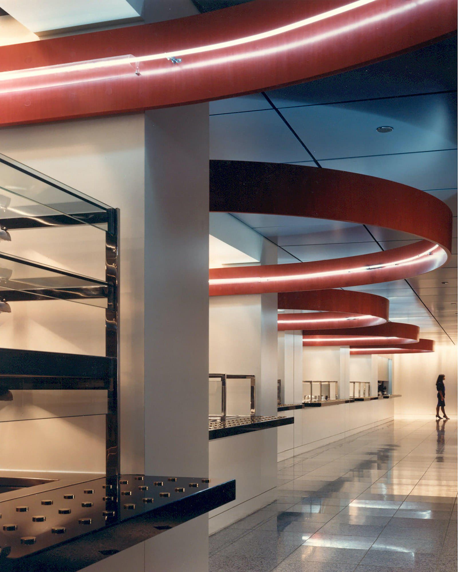 a long hallway in a building with a red ceiling
