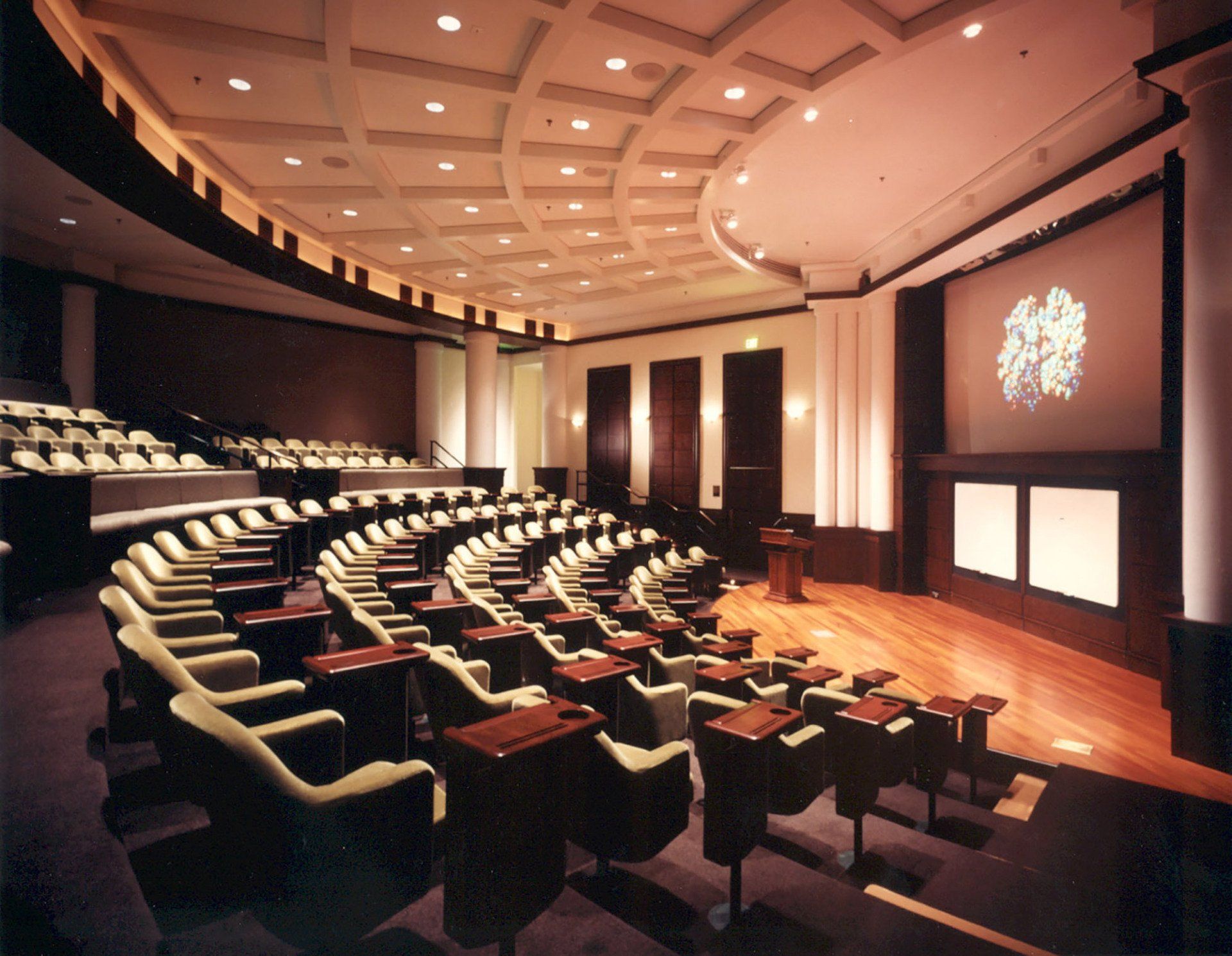 a large auditorium with rows of chairs and a large screen