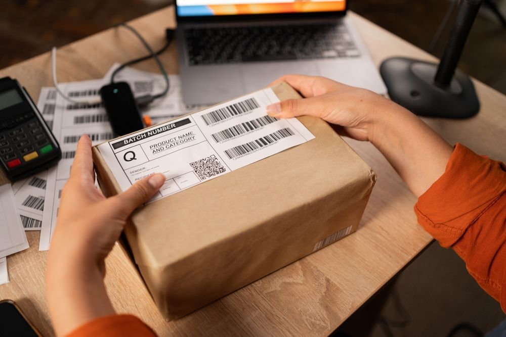 A person is holding a box with a barcode on it.