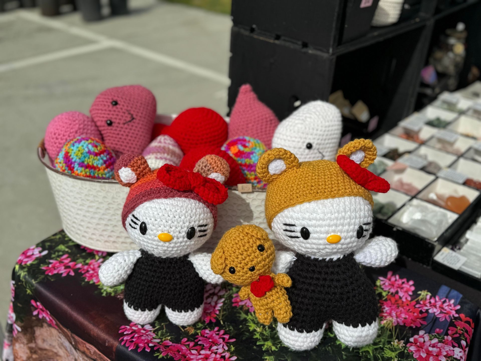 A group of crocheted hello kitty dolls are sitting on a table.
