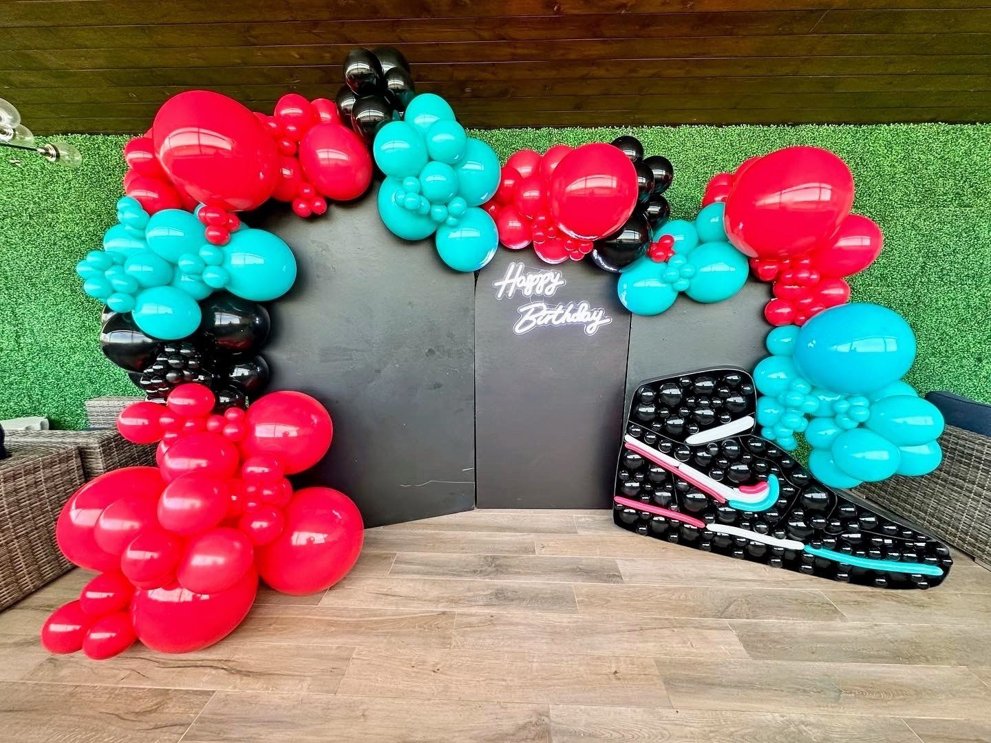 A balloon arch with a nike shoe made out of balloons.
