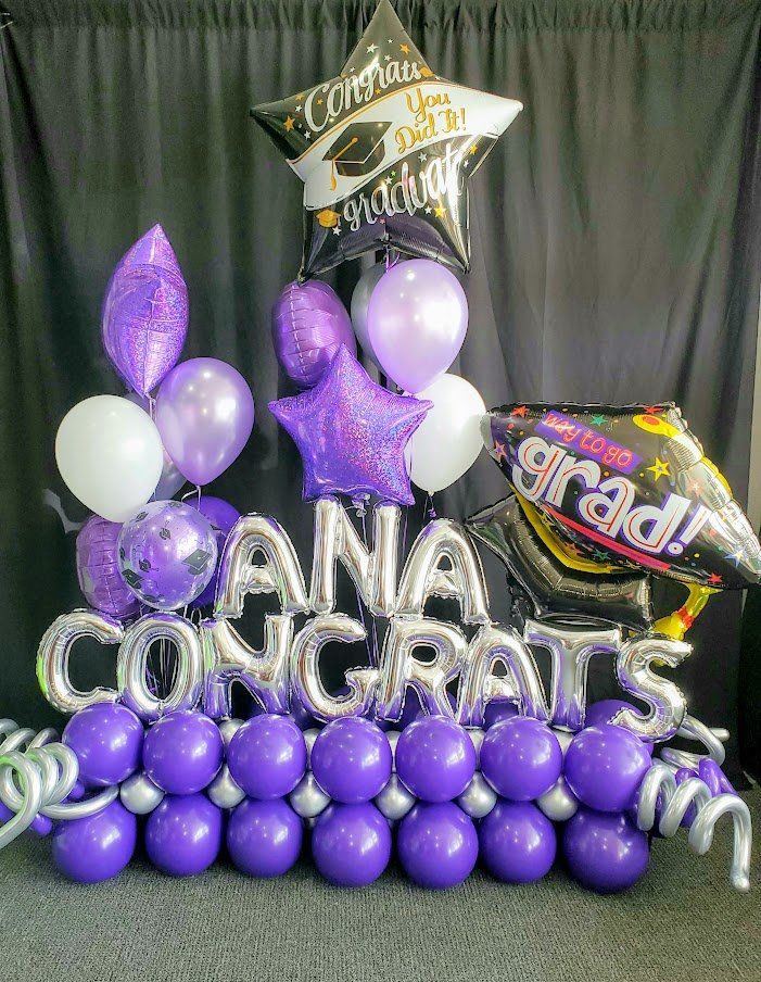 A bunch of purple balloons are sitting on top of each other on a table.