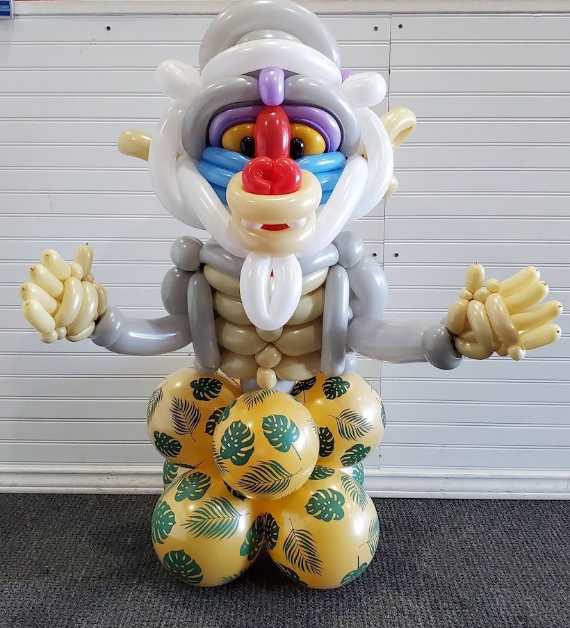 A monkey made out of balloons is sitting on a pile of balloons.
