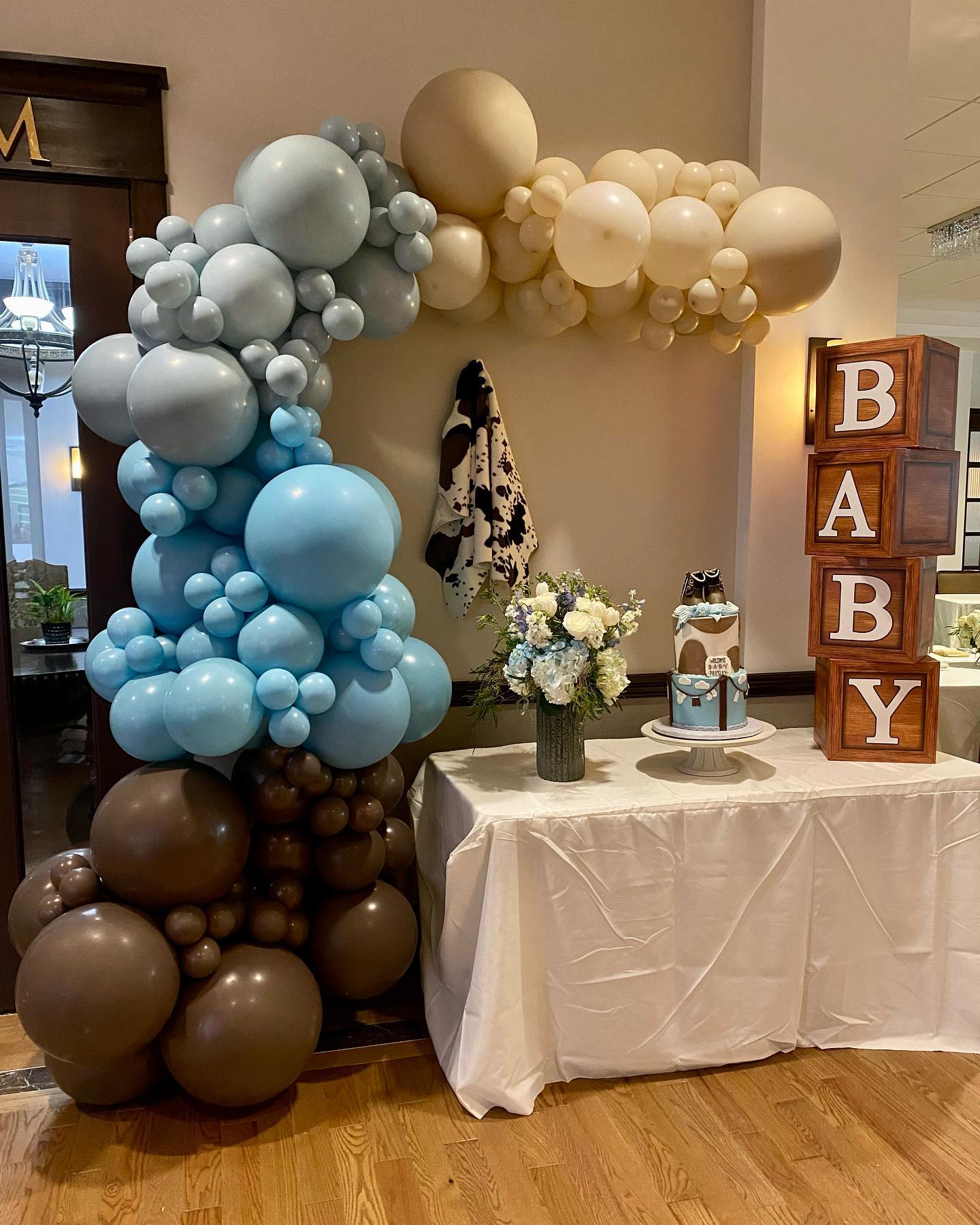 A table decorated with balloons and wooden blocks for a baby shower.