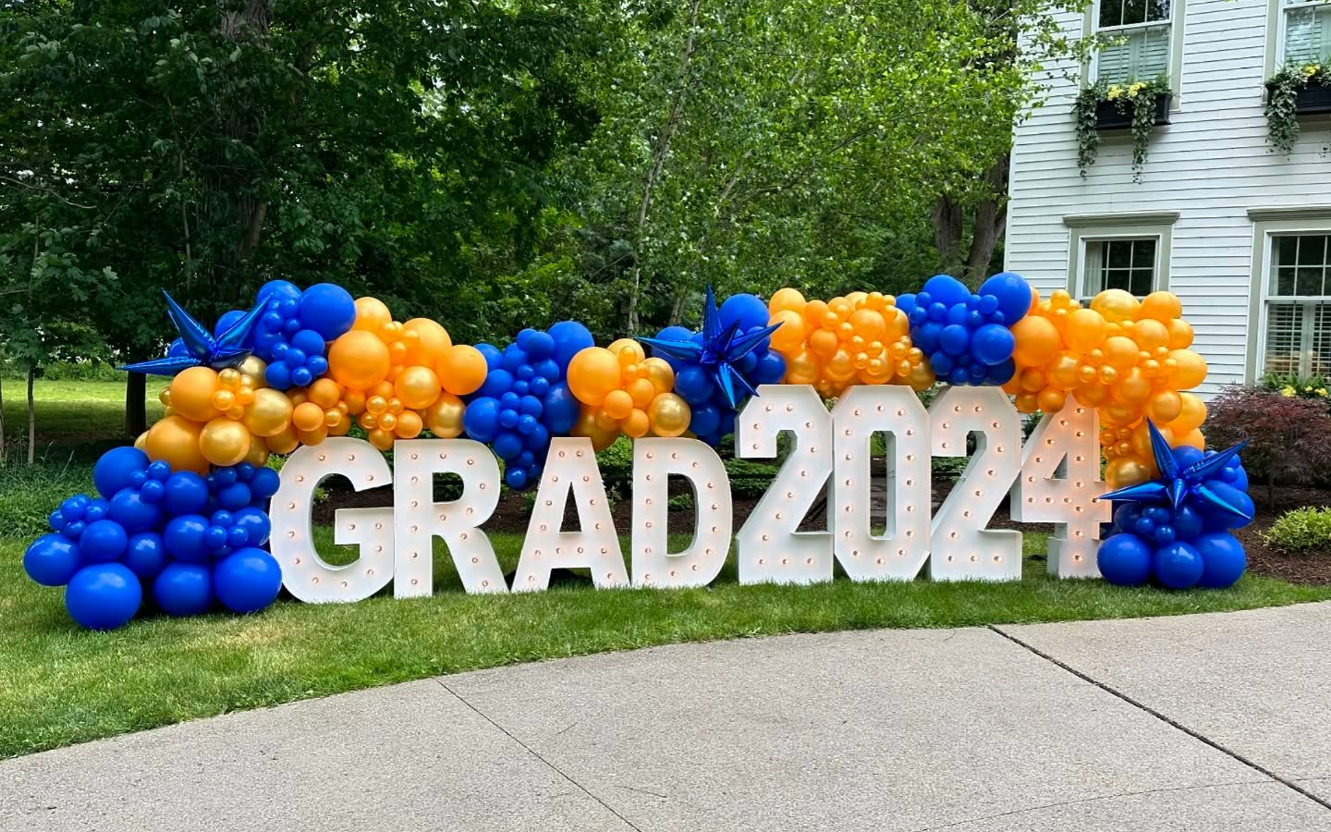 Graduation marquee letters with balloon garland yard display for class celebration in Fort Worth