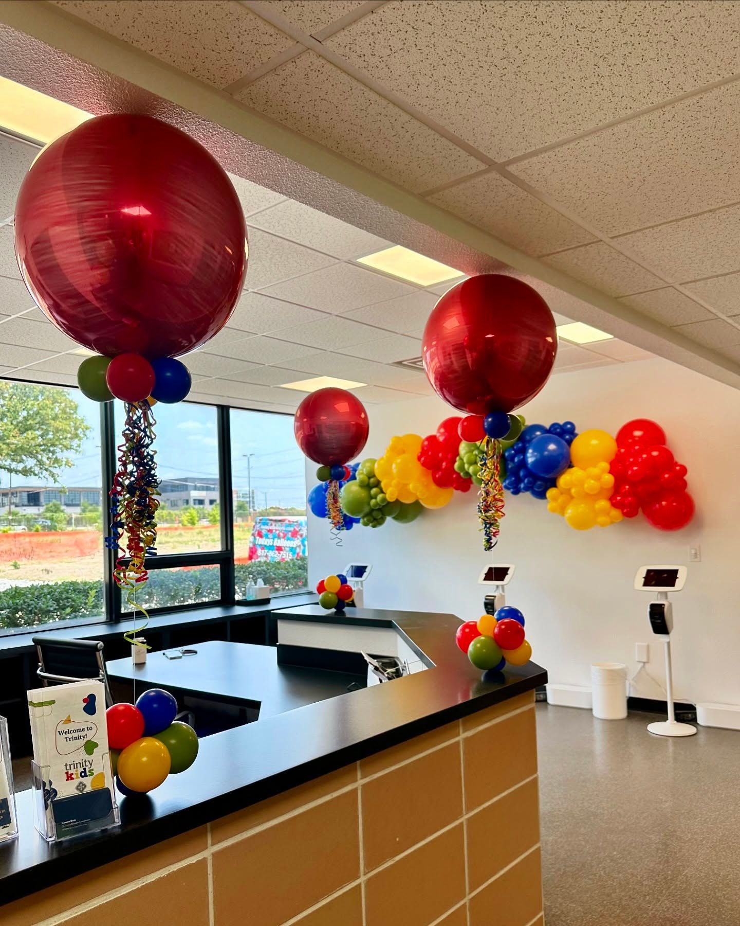 Colorful Balloon garland and matching centerpieces in a school office.