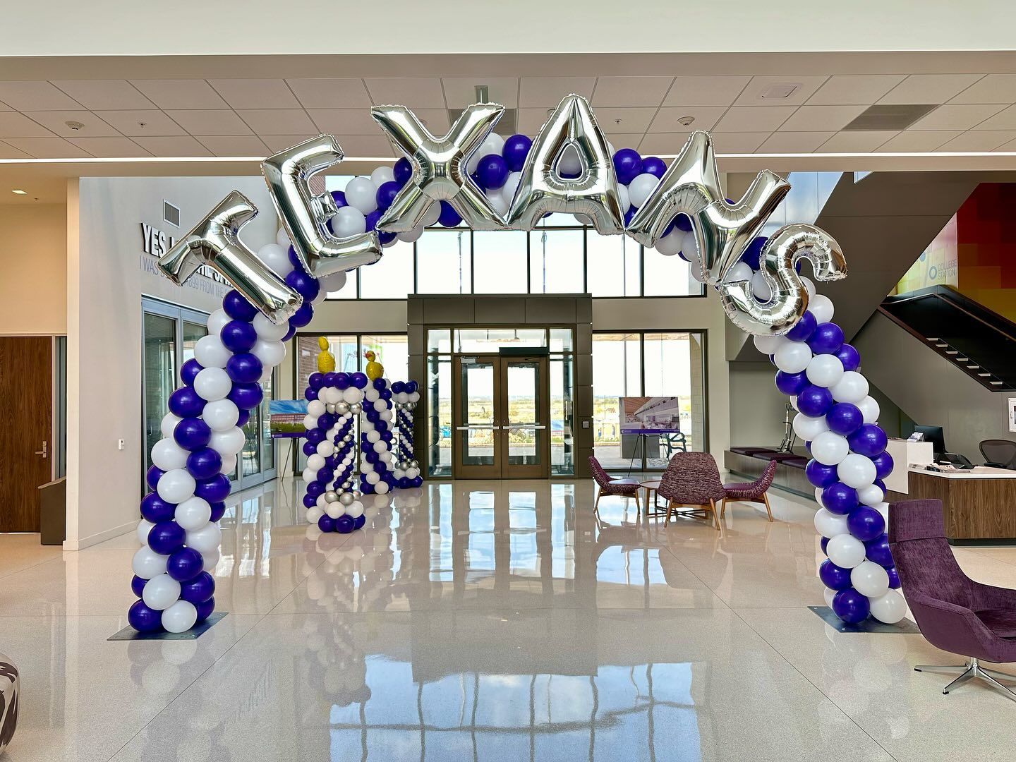 A purple and white balloon arch with