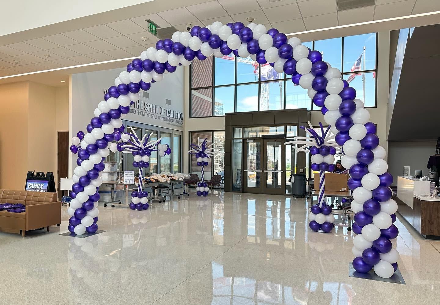 A purple and white air-filled balloon arch at a university for orientation.