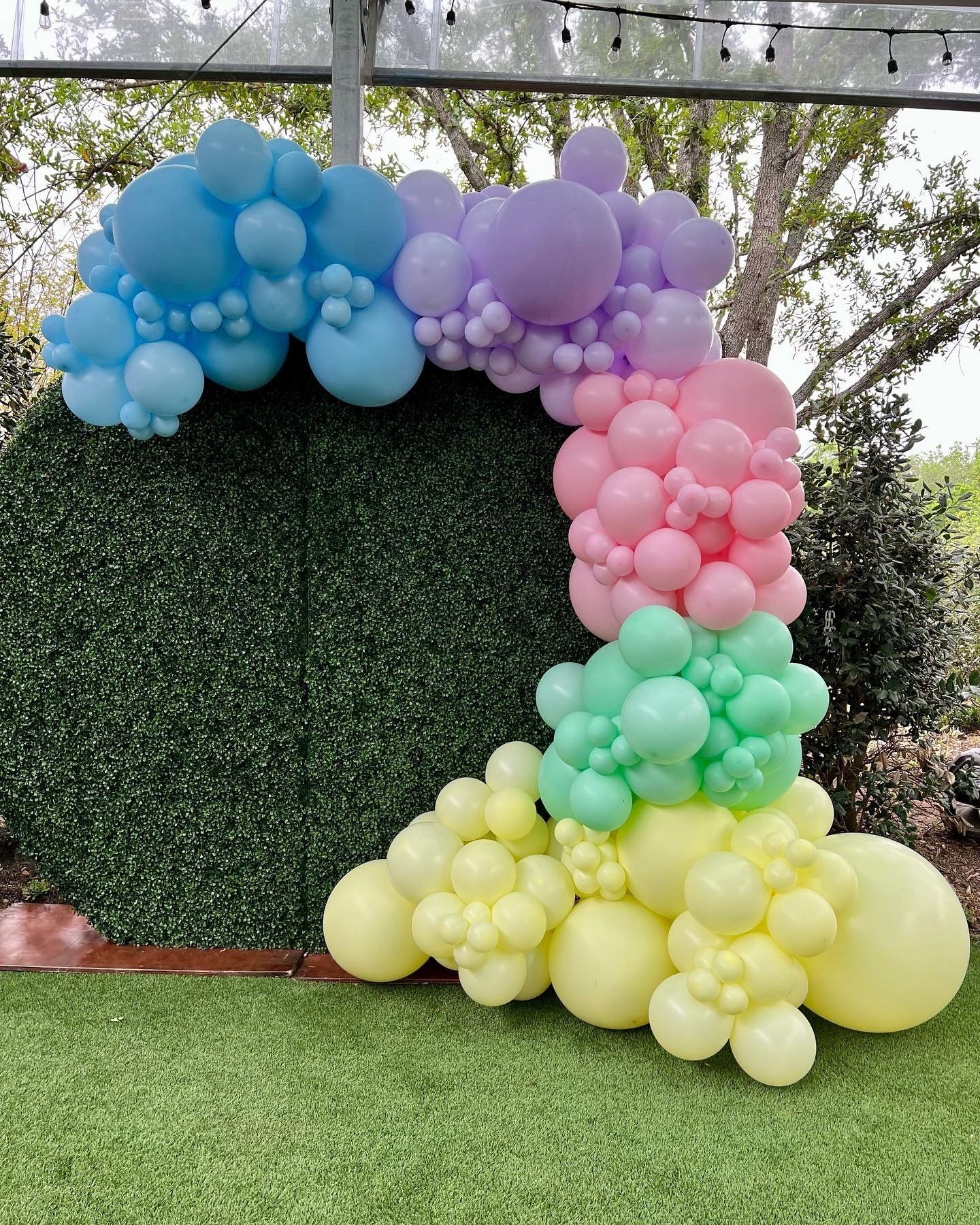 A bunch of balloons are sitting on top of a lush green field.