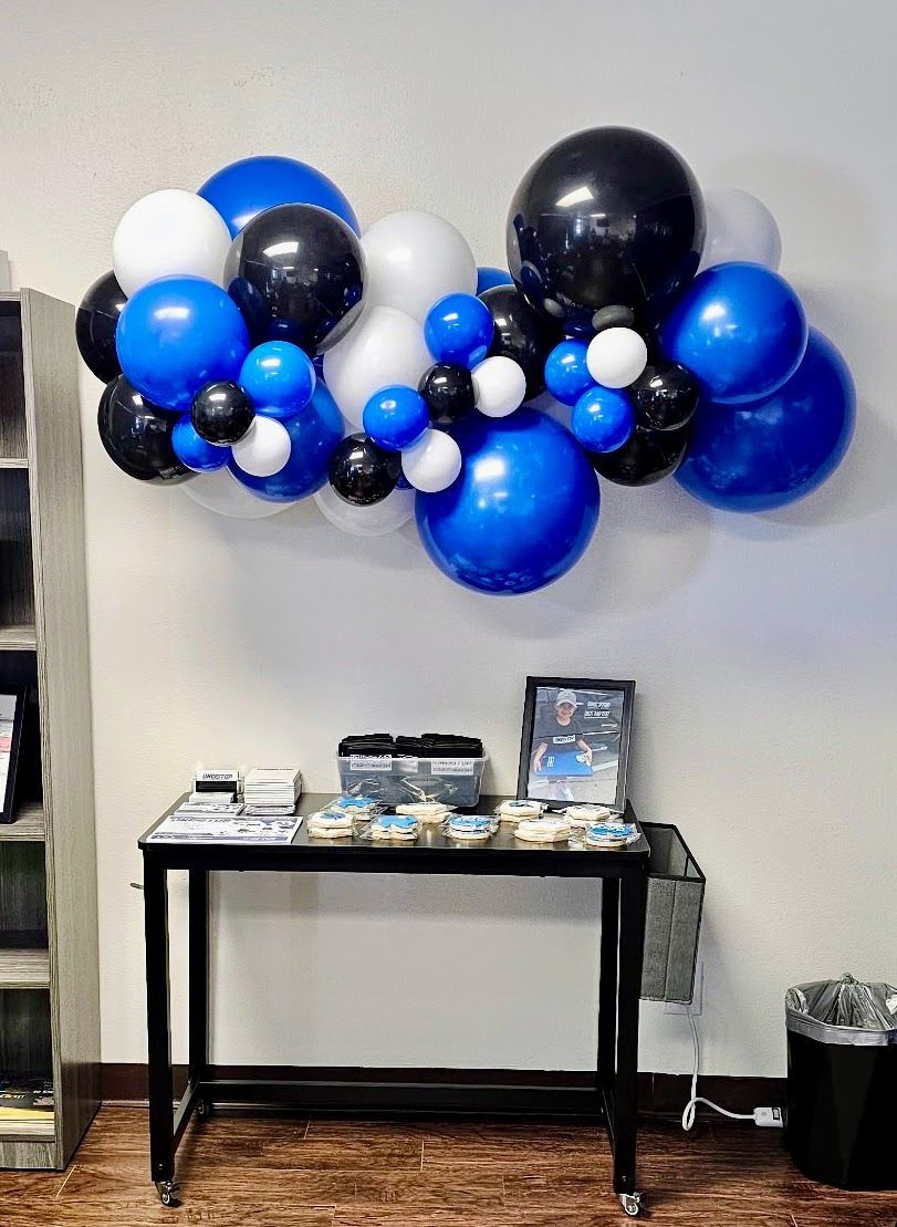 Organic balloon garland backdrop: royal blue, navy, white. Cloud-style, varied latex balloons, elegant modern design.