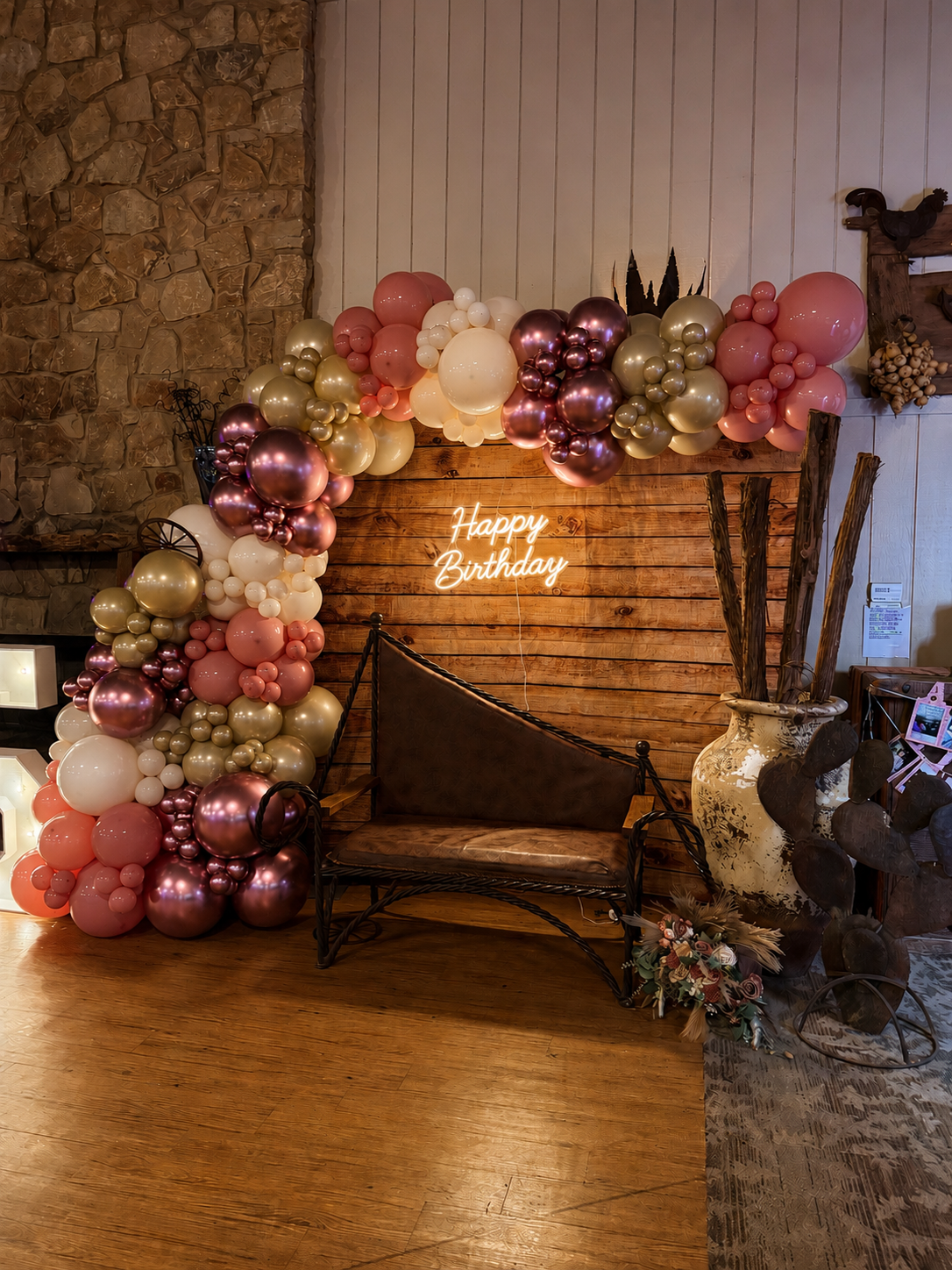 A gorgeous 15th birthday balloon garland with an organic style set up with a backdrop and neon sign.