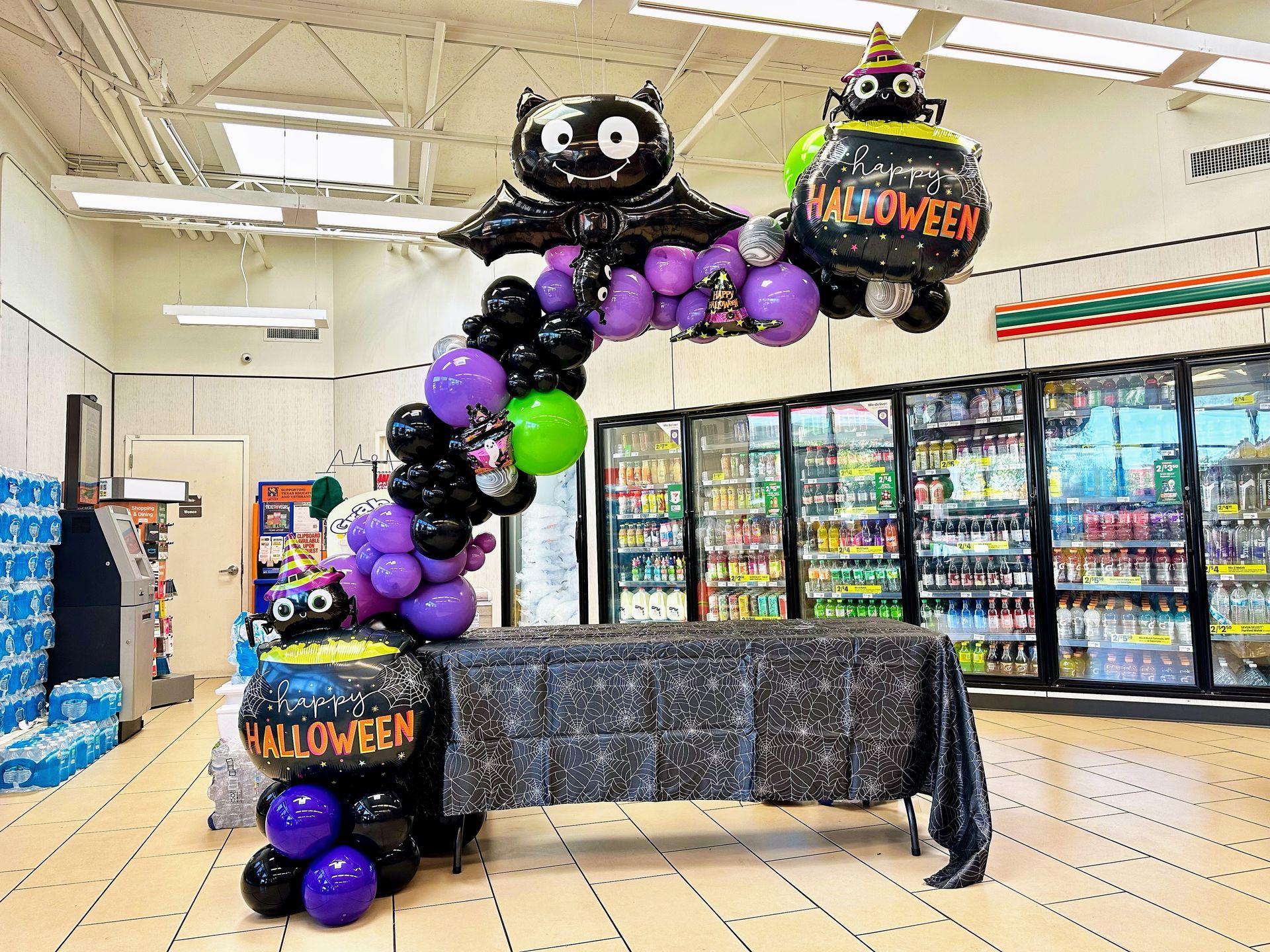 A table is decorated with balloons in a store for halloween.