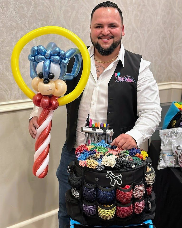 A man is holding a mickey mouse balloon and a candy cane balloon.