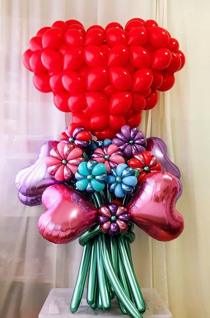 A bouquet of balloons in the shape of a heart and flowers