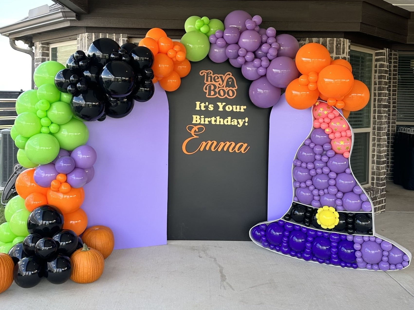 Celebration themed balloon garland featuring colorful balloons styled with a custom backdrop panel