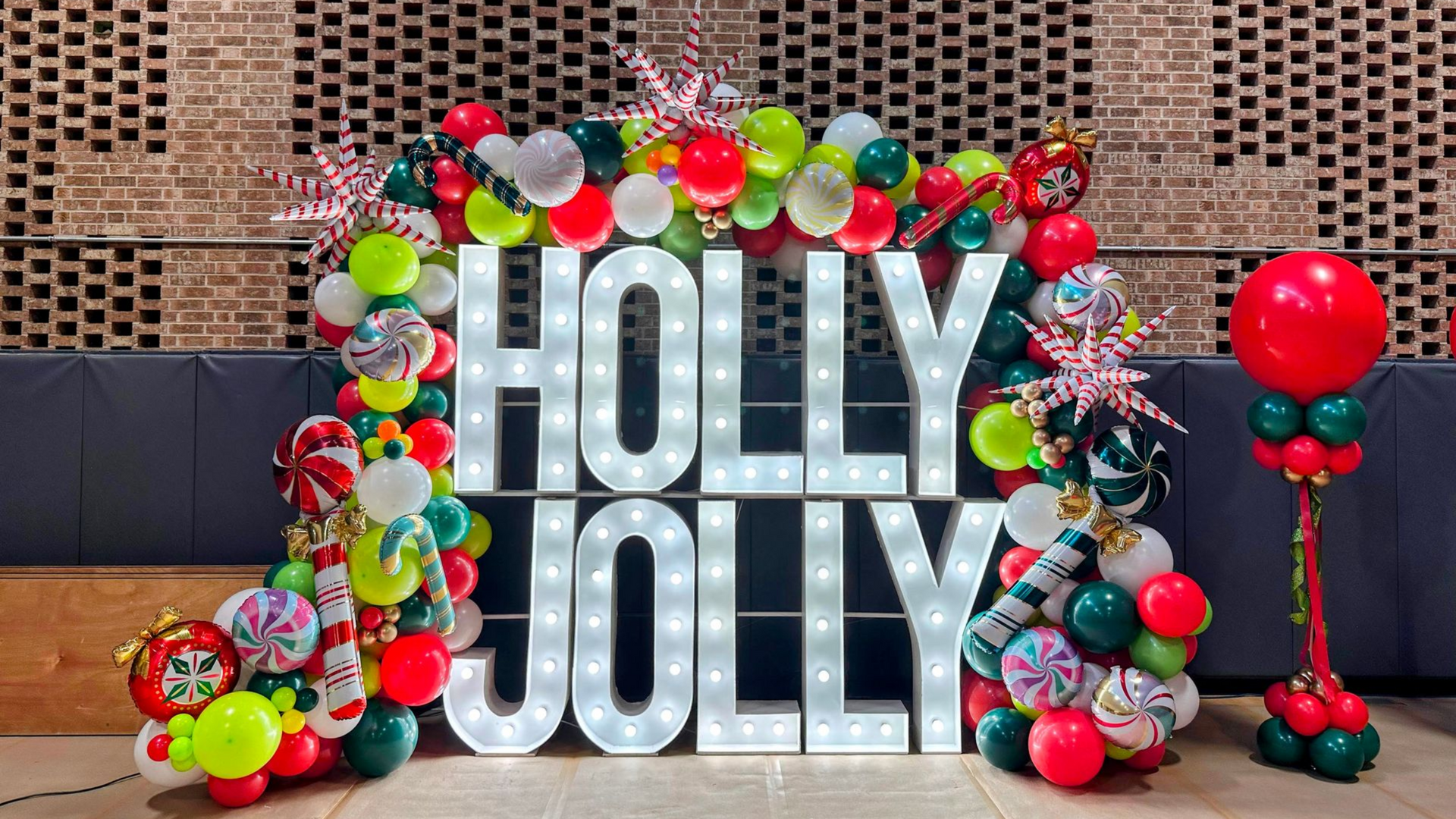 Holly Jolly Christmas balloon display with festive colors and holiday-themed balloon décor for corporate and private events