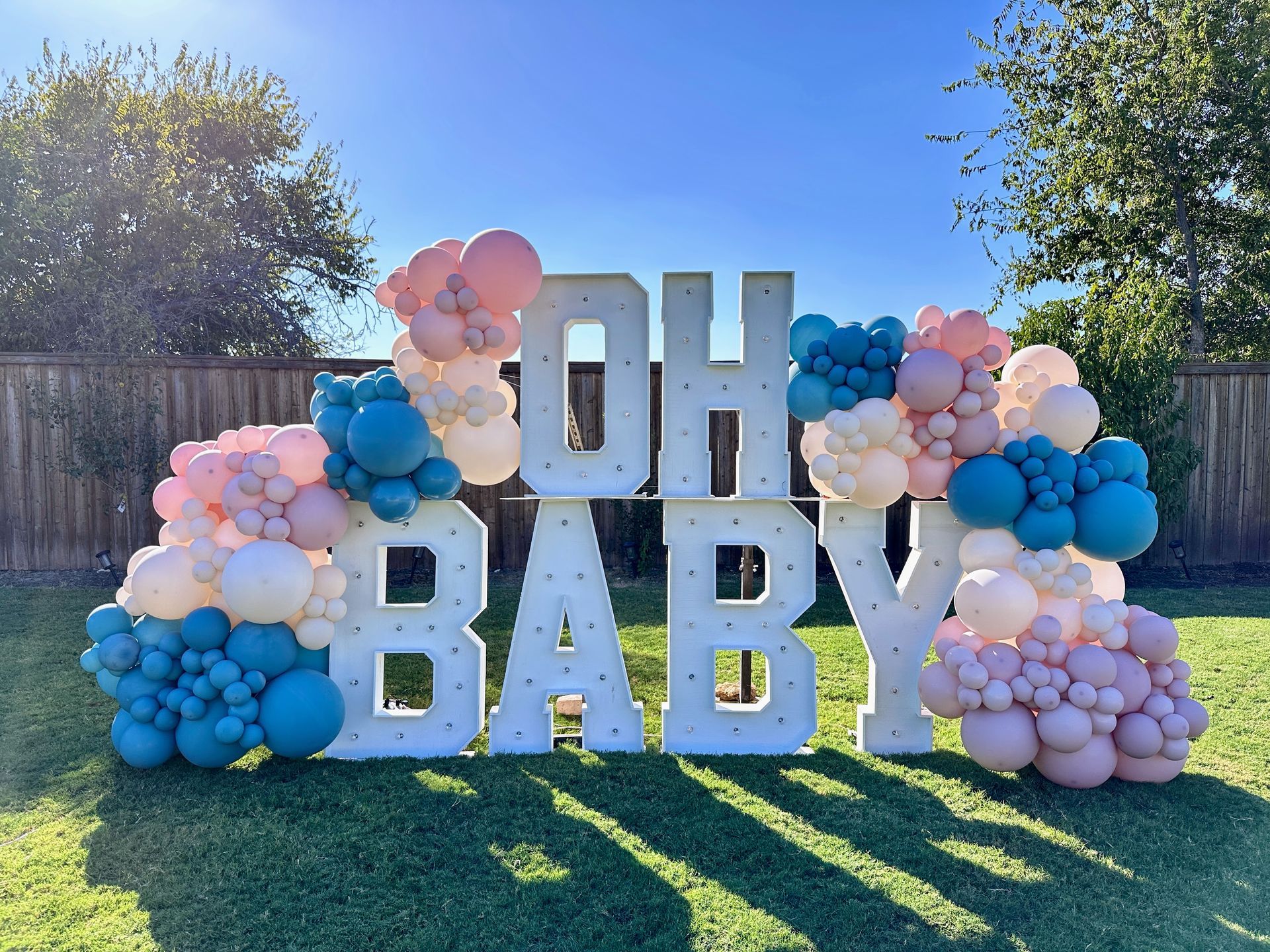 Baby shower balloon garland featuring soft pink, blue, and neutral balloons styled for a baby celebration