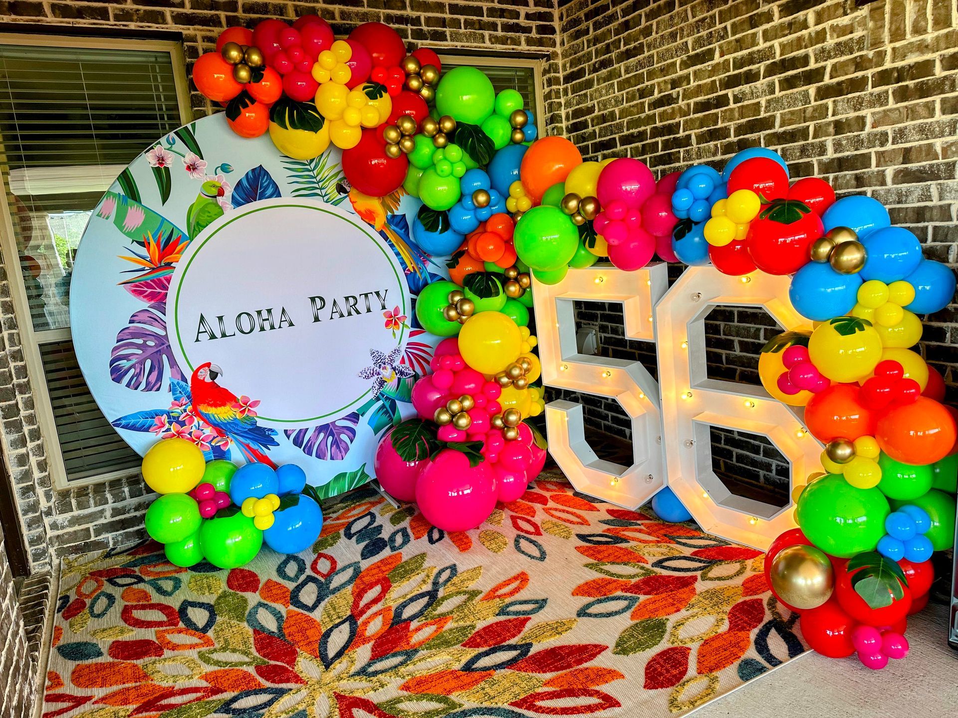 A room filled with balloons and a sign that says `` aloha party ''.