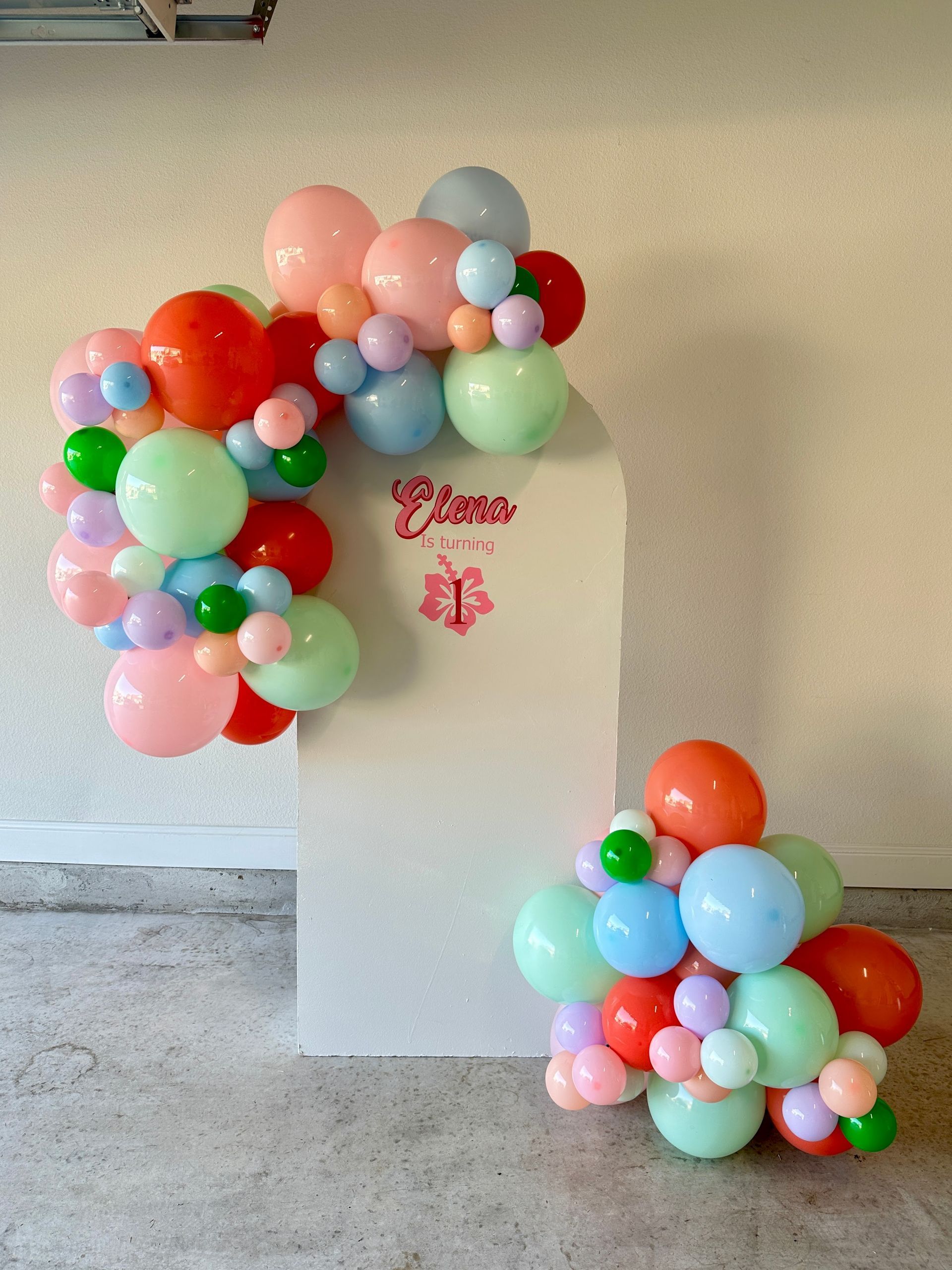 Pastel balloon garland featuring soft pink, green, blue, and peach balloons for a celebration backdrop