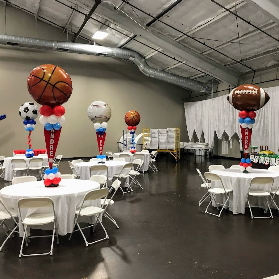 A room filled with tables and chairs decorated with balloons.
