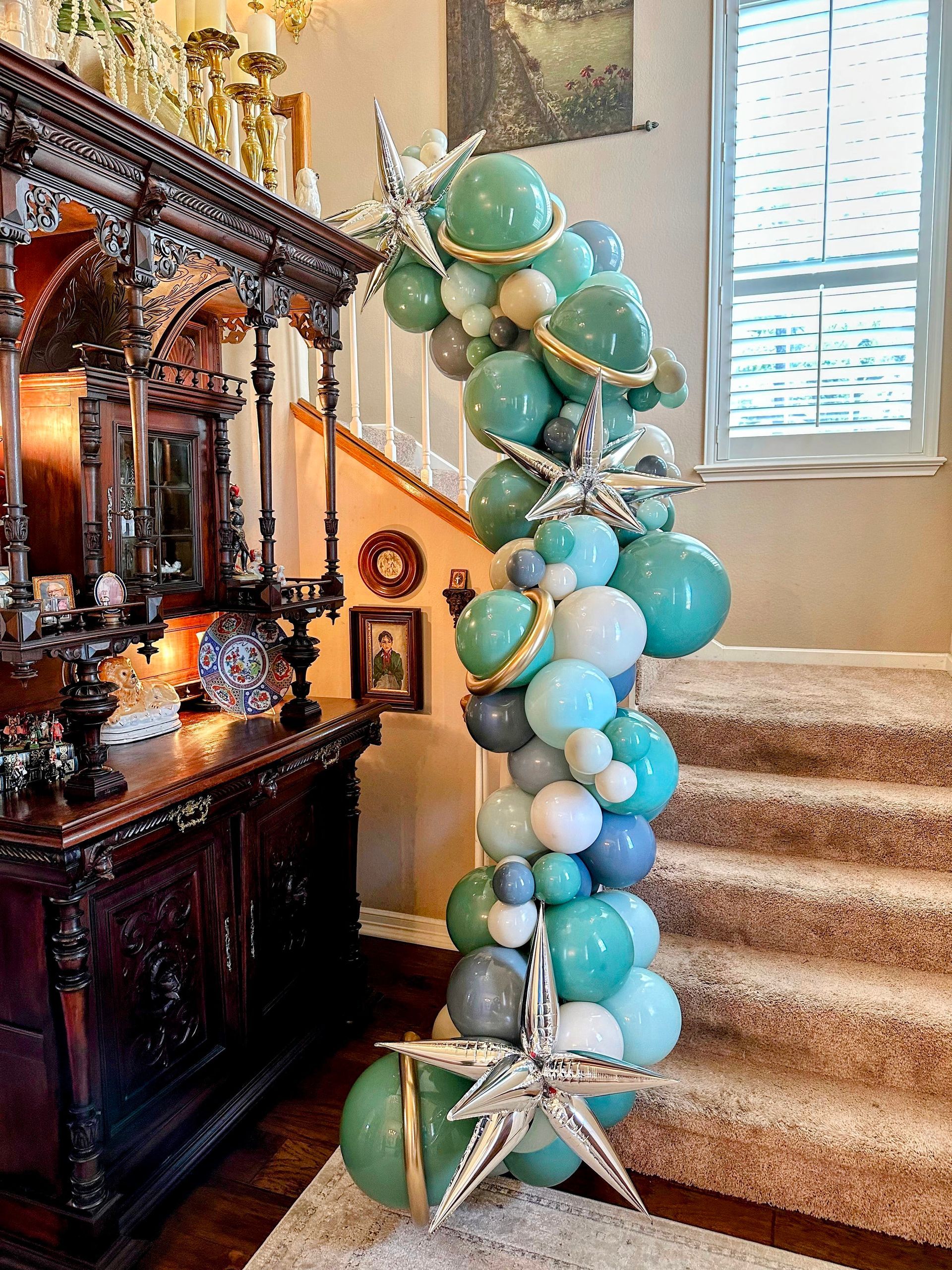 A staircase is decorated with balloons and a starfish.