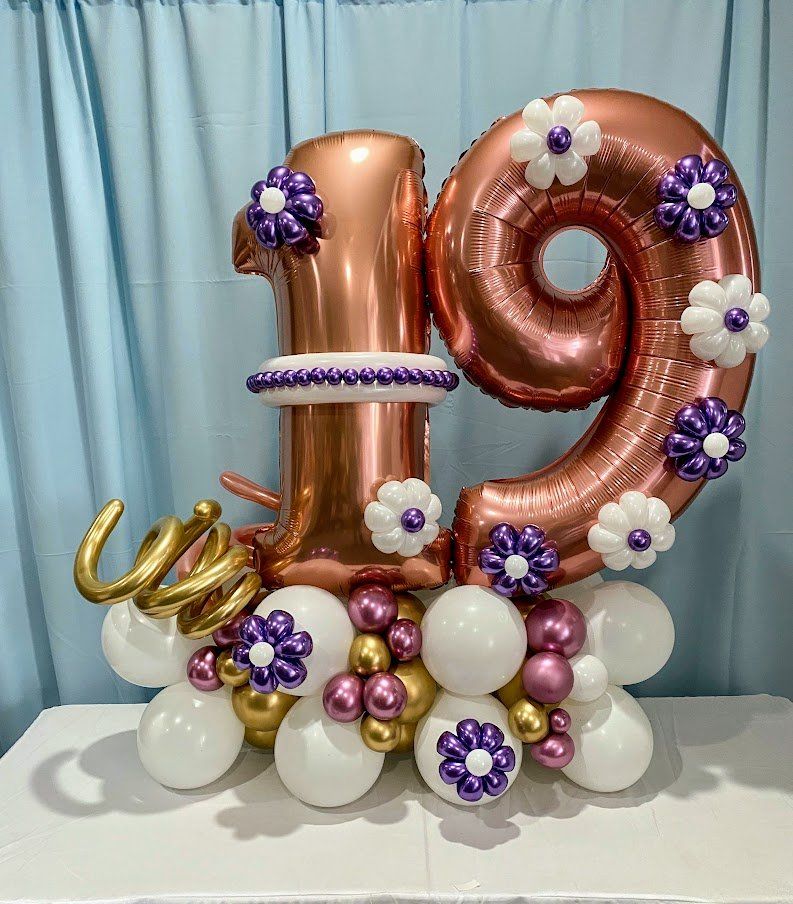 Floral accented number balloon marquee bouquet designed for milestone celebrations and styled events