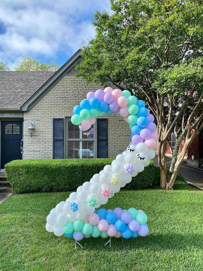 A number two made of balloons in front of a house.