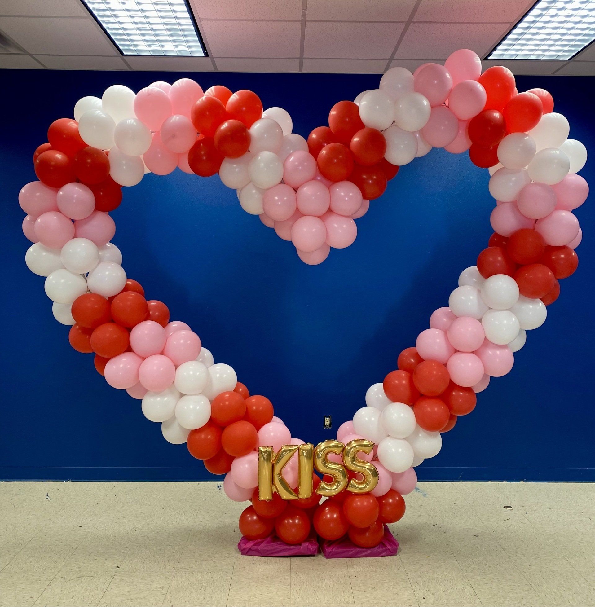 A heart made of balloons with a kiss sign in the middle