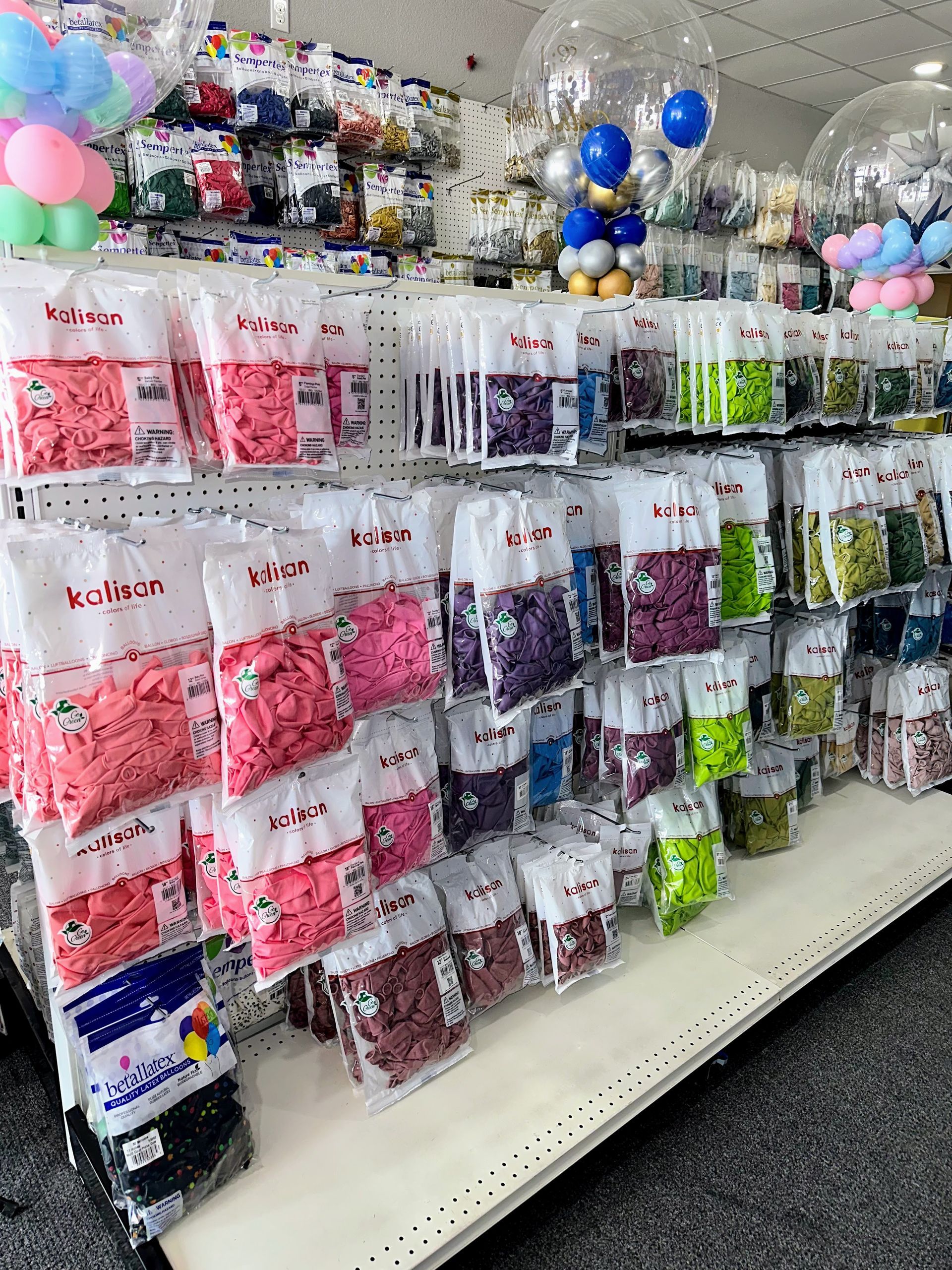 A shelf filled with bags of balloons in a store.