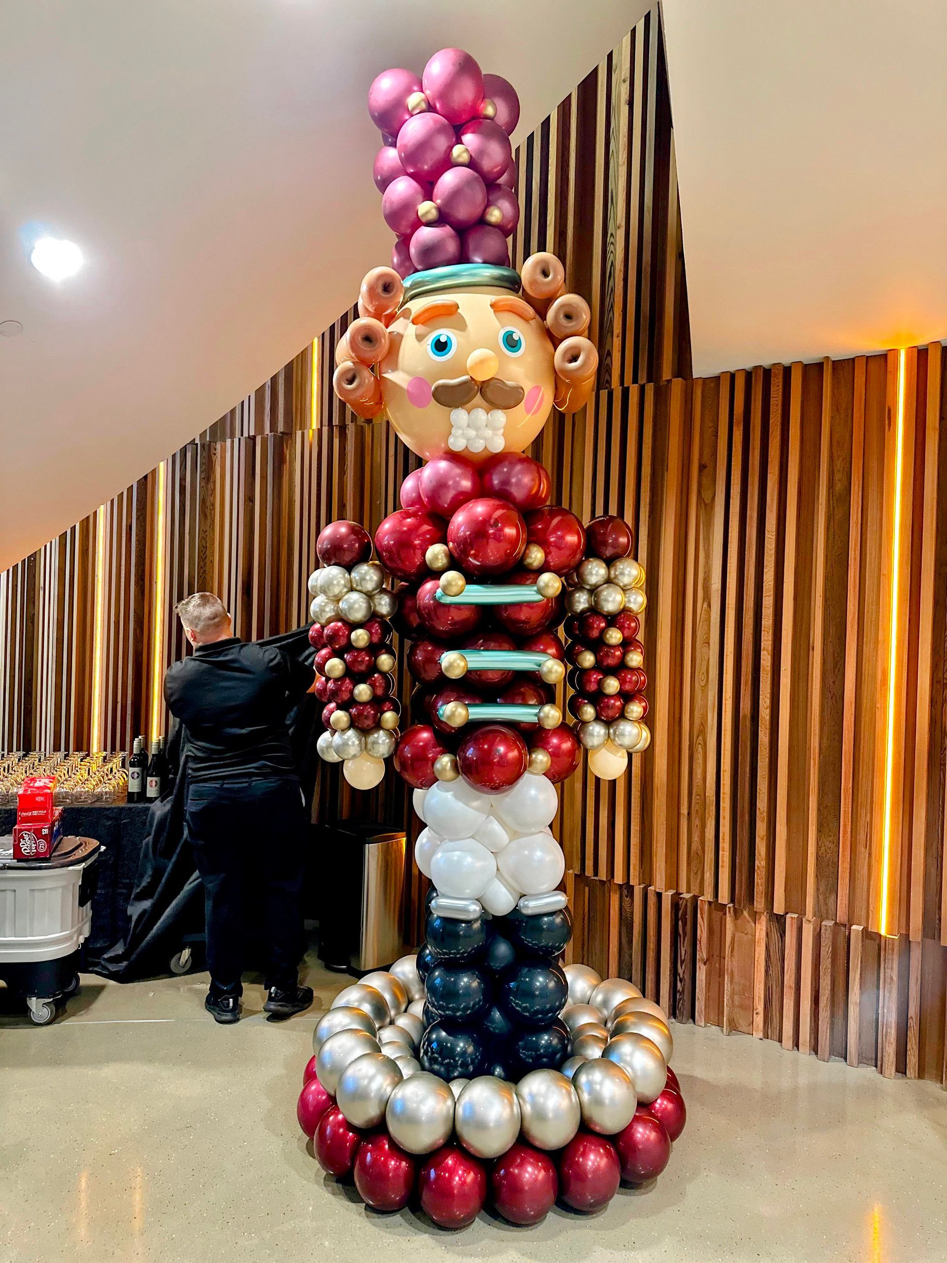 Nutcracker-themed Christmas balloon décor with red, gold, and festive balloon accents for holiday celebrations