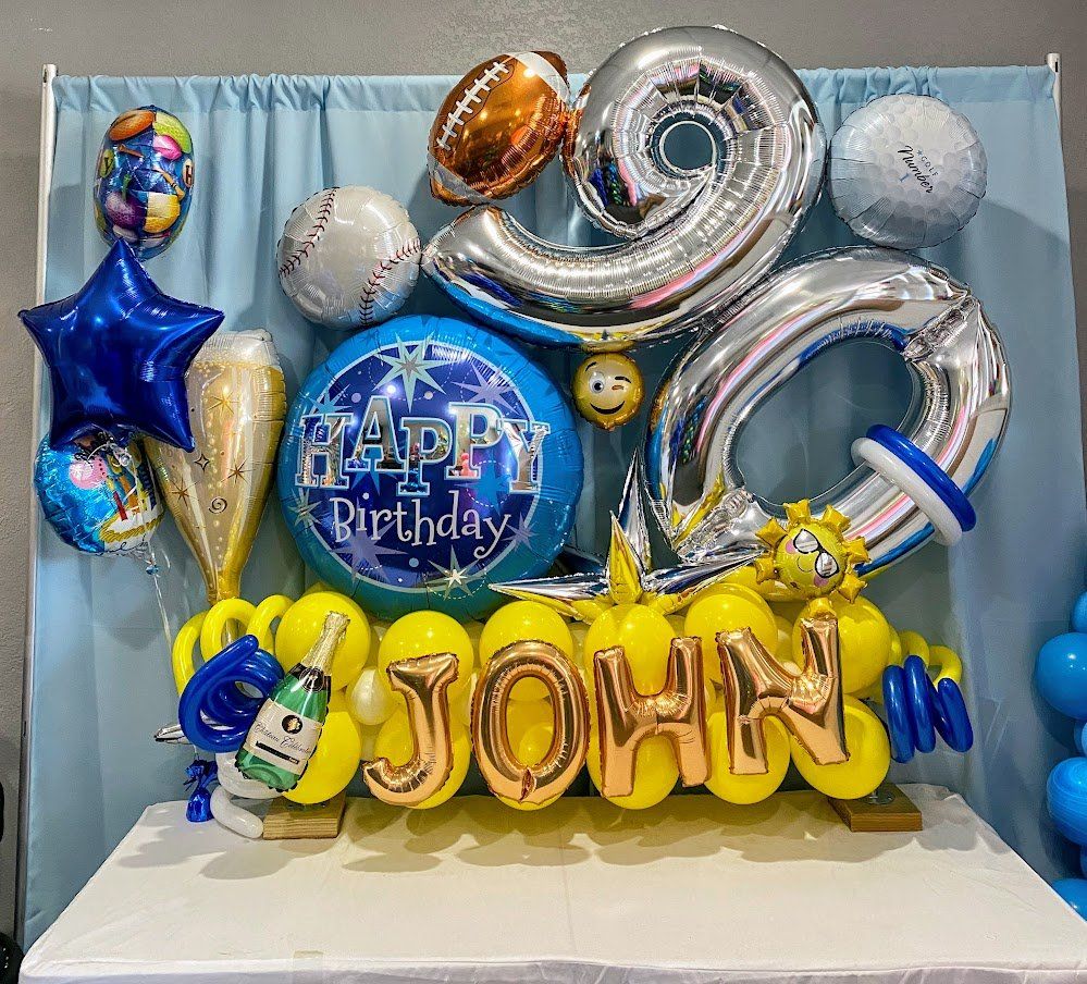 A table topped with balloons and a sign that says `` happy birthday john ''.