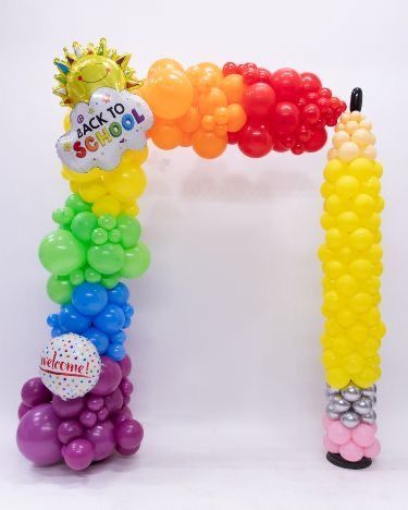 Classroom-inspired balloon backdrop with pencils, books, and colorful balloon décor for back to school events