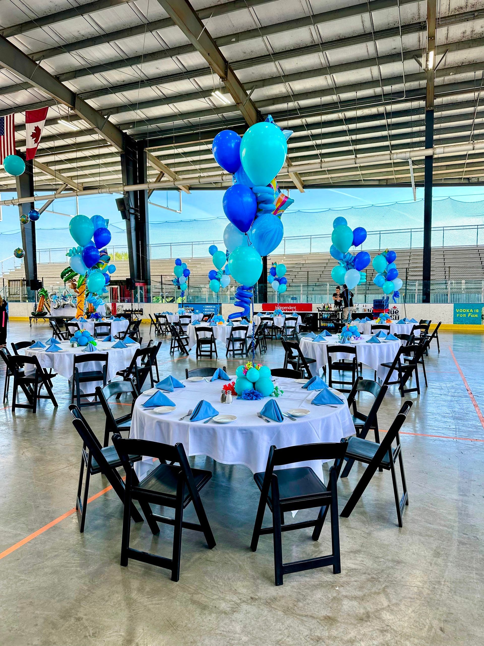 an outdoor corporate party with blue balloon centerpieces.