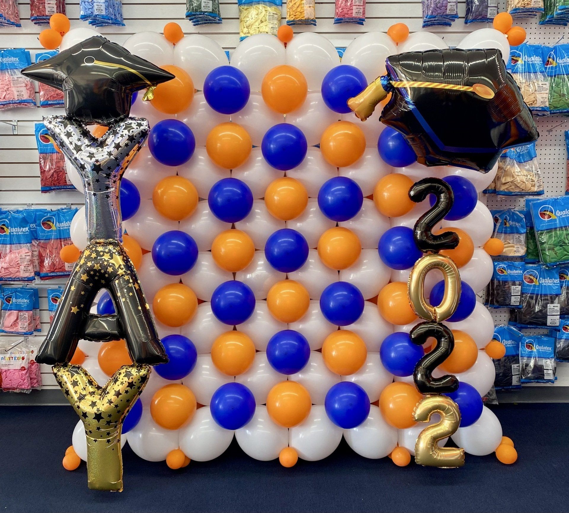 A wall of balloons with a graduation cap and the year 2022
