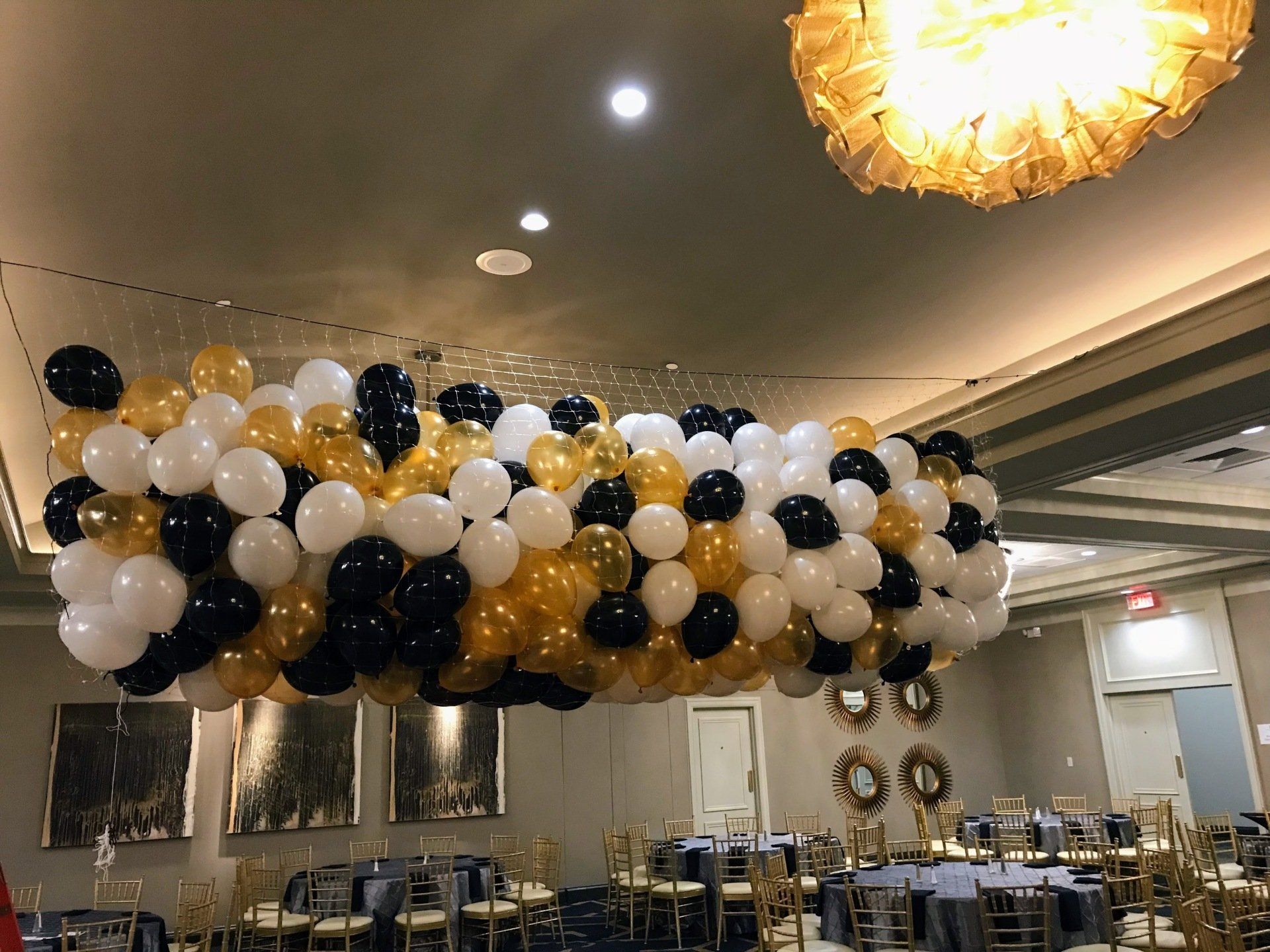 A bunch of balloons are hanging from the ceiling of a room.