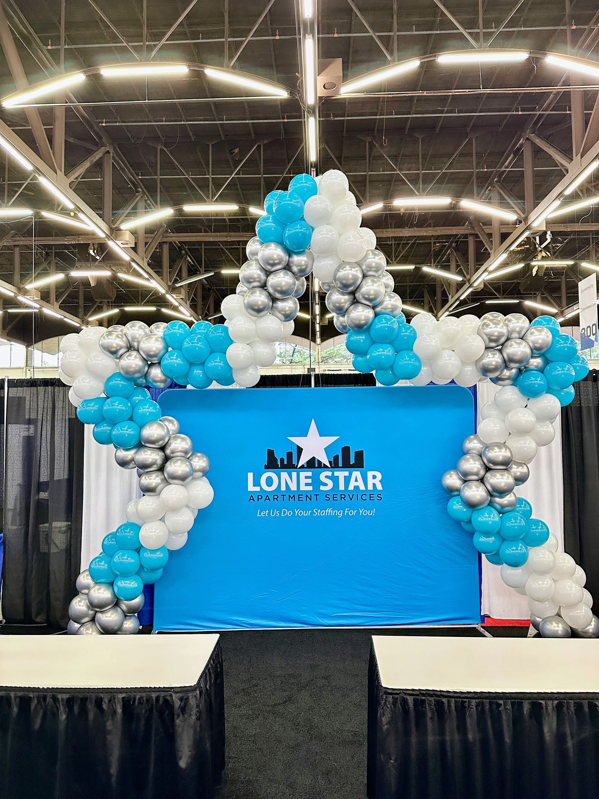 Branded corporate balloon backdrop with star shaped balloon frame and custom logo display for business event
