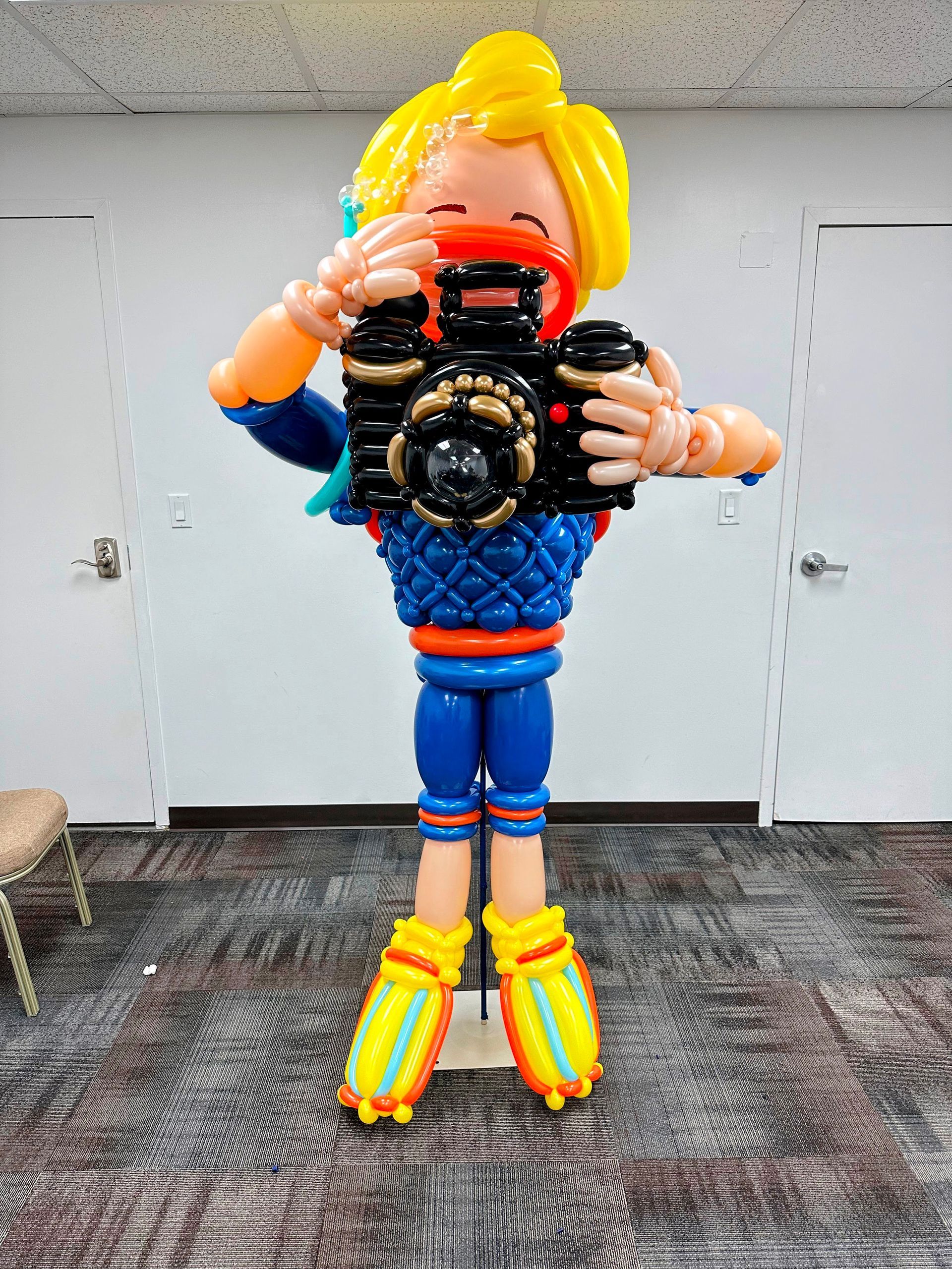 A balloon sculpture of a person taking a picture with a camera