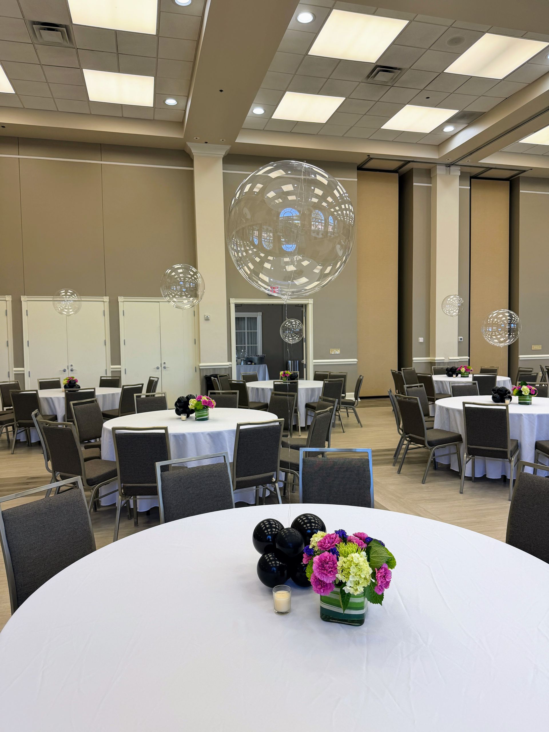 Simple and classic bubble balloon centerpieces for each table at a celebration.