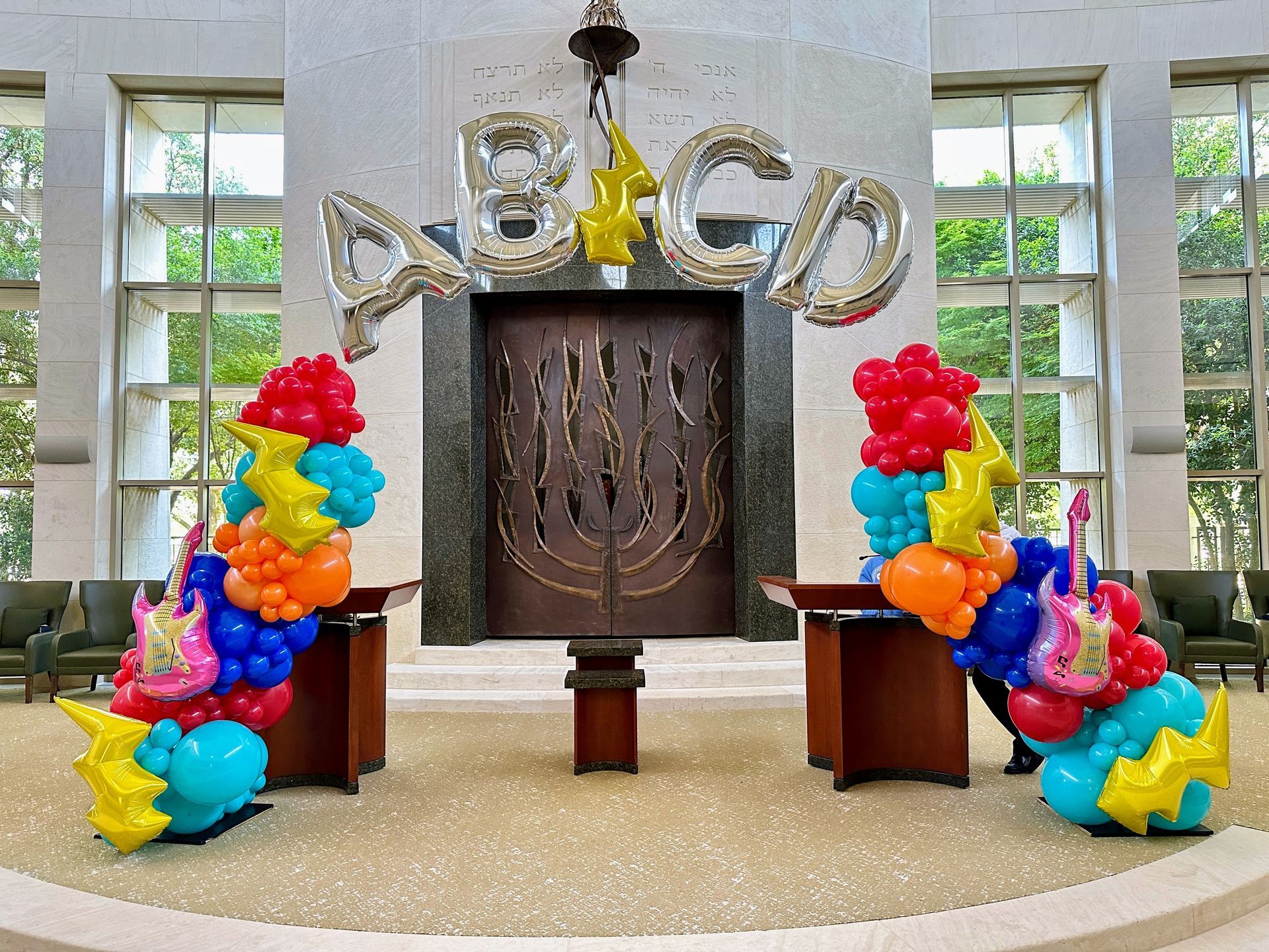 Music themed balloon garland featuring neutral balloons and guitar accents for an entertainment event