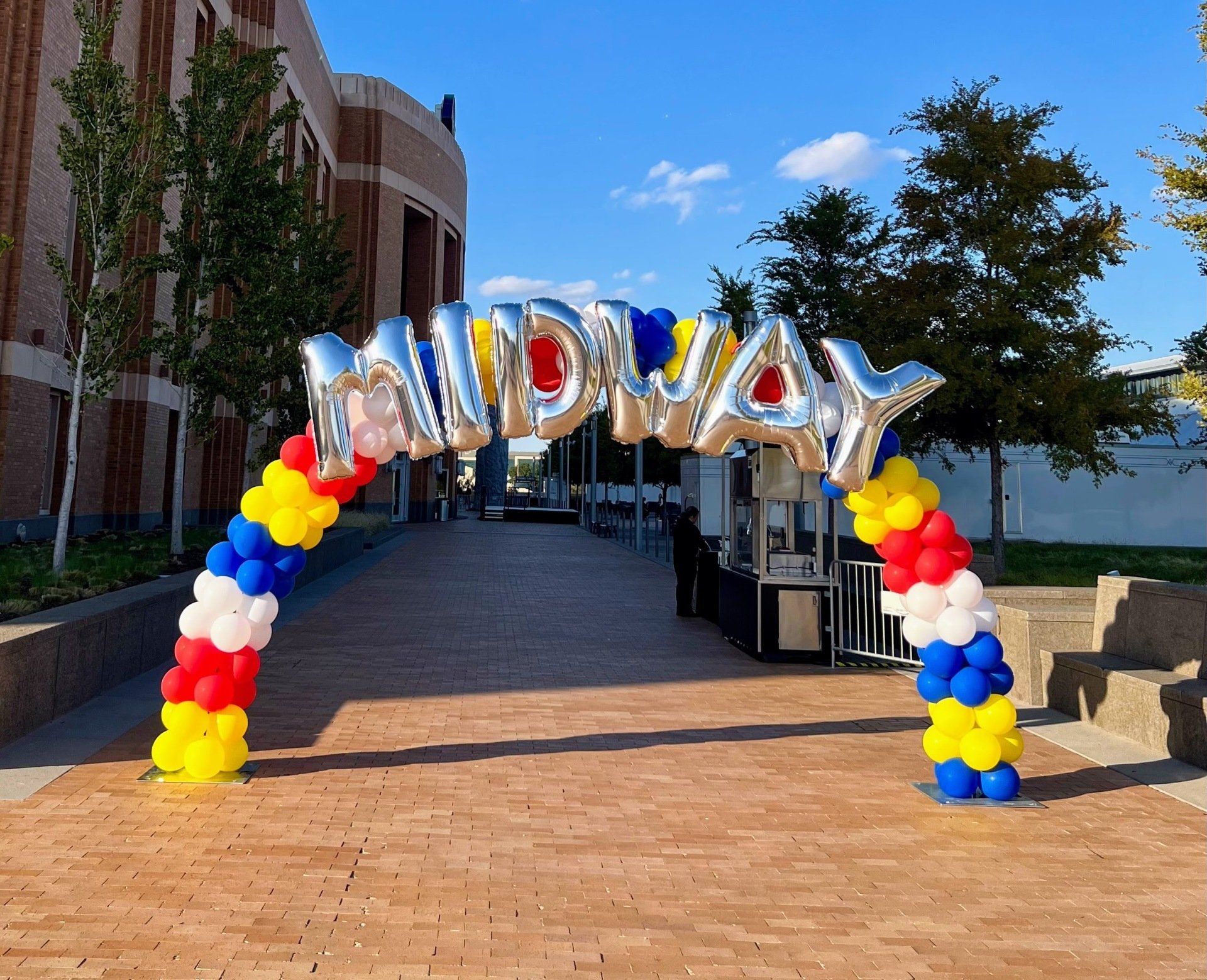 A balloon arch with the word midway on it