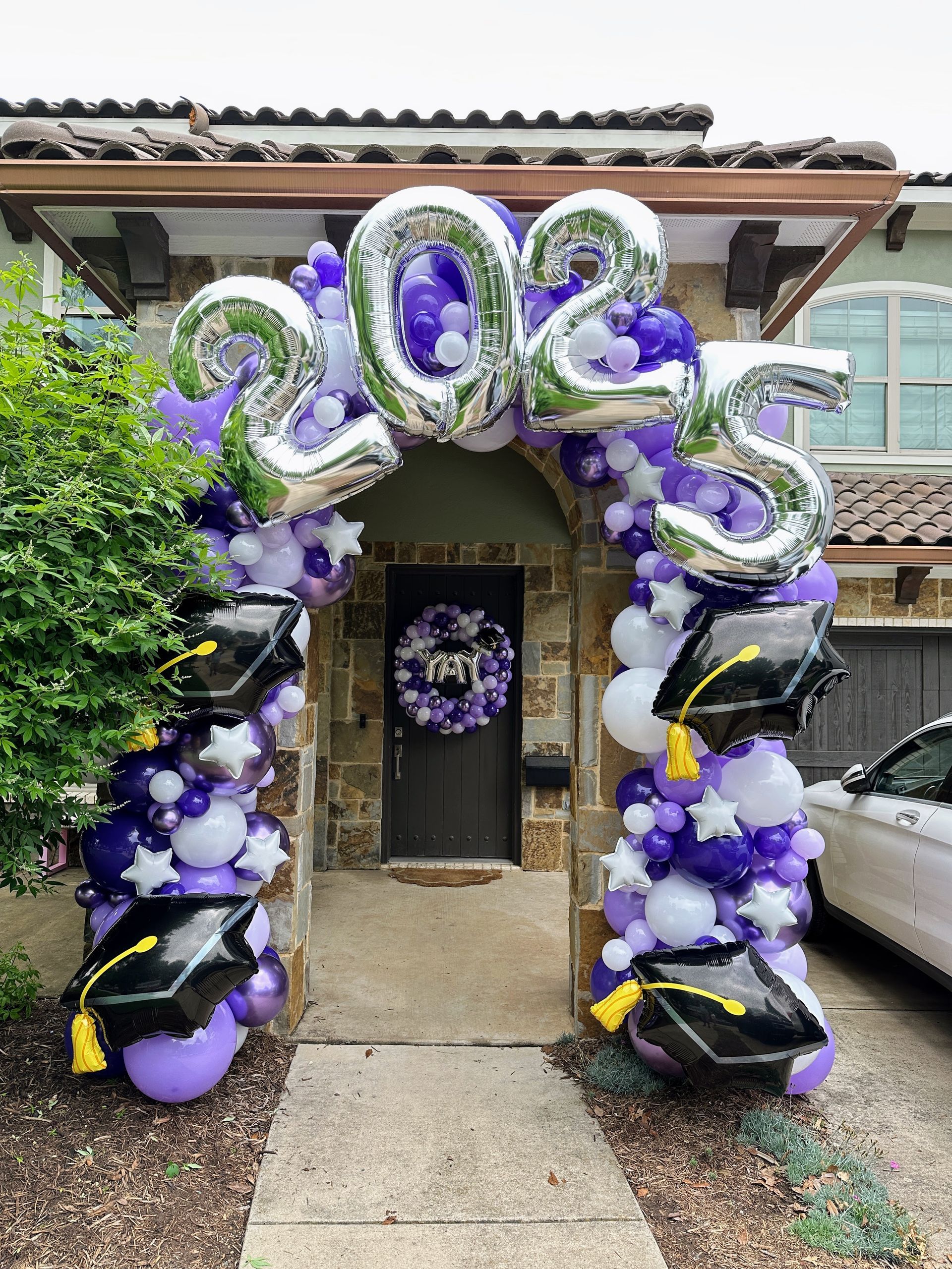 Graduation balloon décor featuring purple and white balloons arranged to celebrate the class of 2025