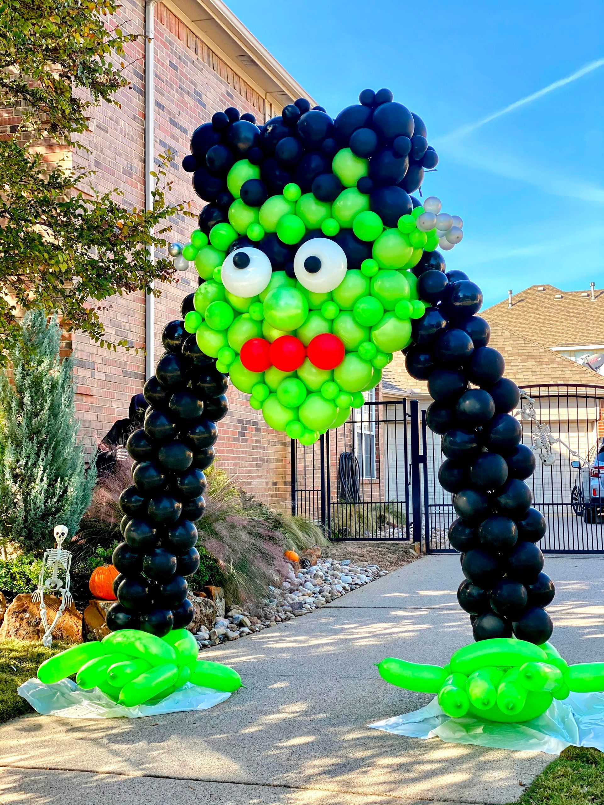 Green and black balloon sculpture with character design for a Halloween or themed party display.