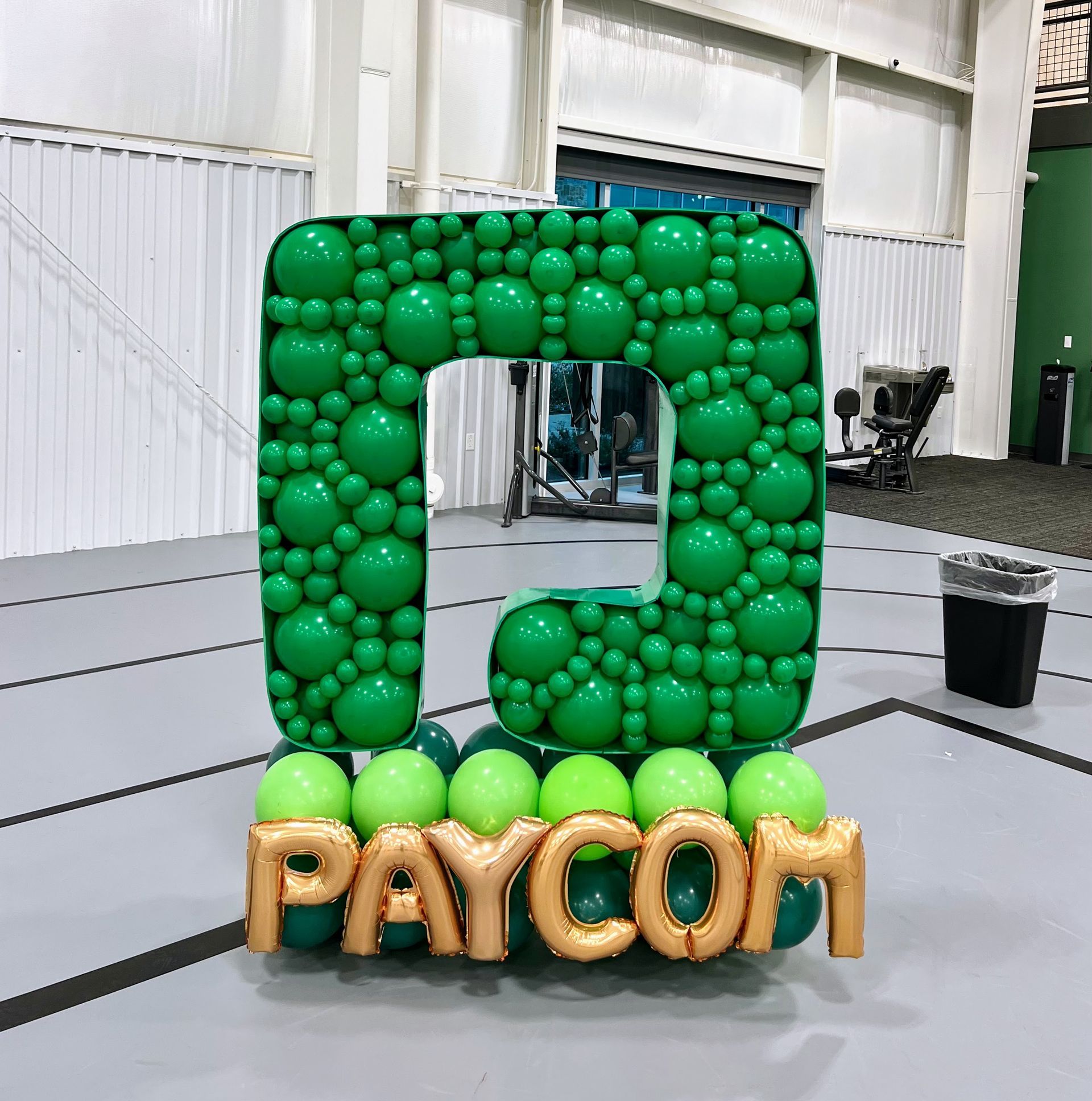 A large letter c made of green balloons and the word paycom