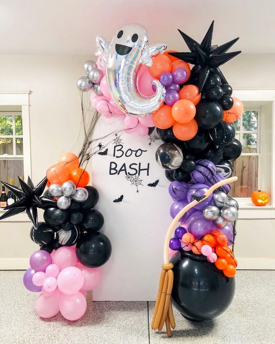 Halloween balloon arrangement with ghost character and pastel balloons for a seasonal event display.